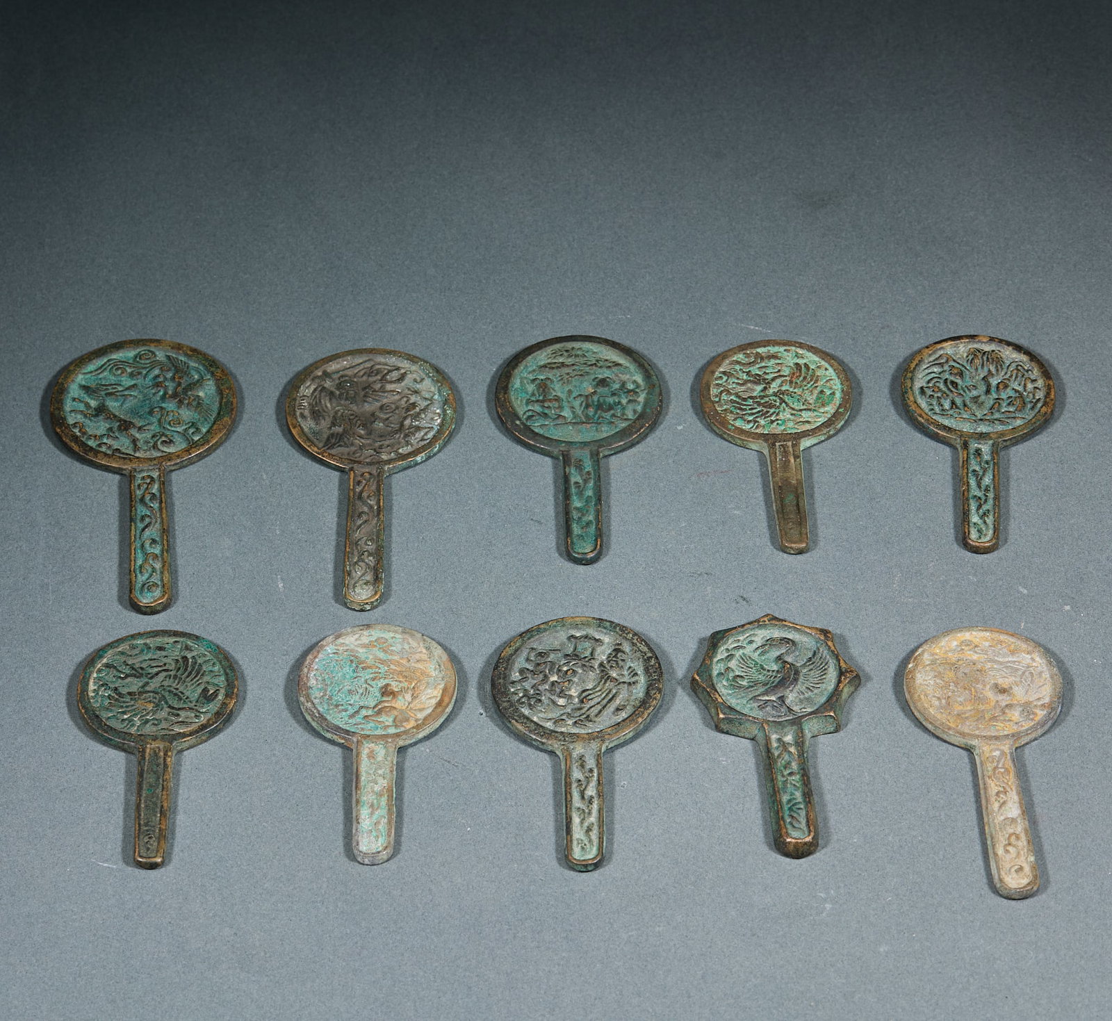 Set of 10 Bronze Mirrors: Bronze Mirror Set (10 Pieces): Regular copper casting craft, diverse patterns on the reverse including flower-and-bird, figure and auspicious beast motifs with natural patina and delicate compact form