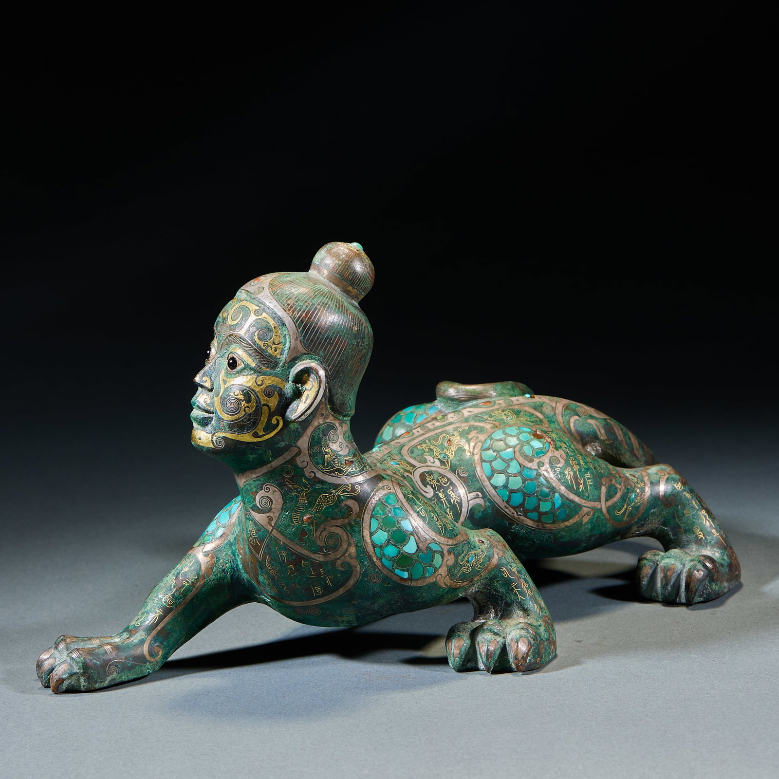 Warring States to Han Period Gold and Silver Inlaid Turquoise Human-Faced Beast Body Ornament: Warring States–Han Gold-Silver Turquoise Inlaid Human-Faced Beast Ornament: Bronze cast with full gold-silver and turquoise inlay, peculiar human-faced beast-body form and magnificent decorative