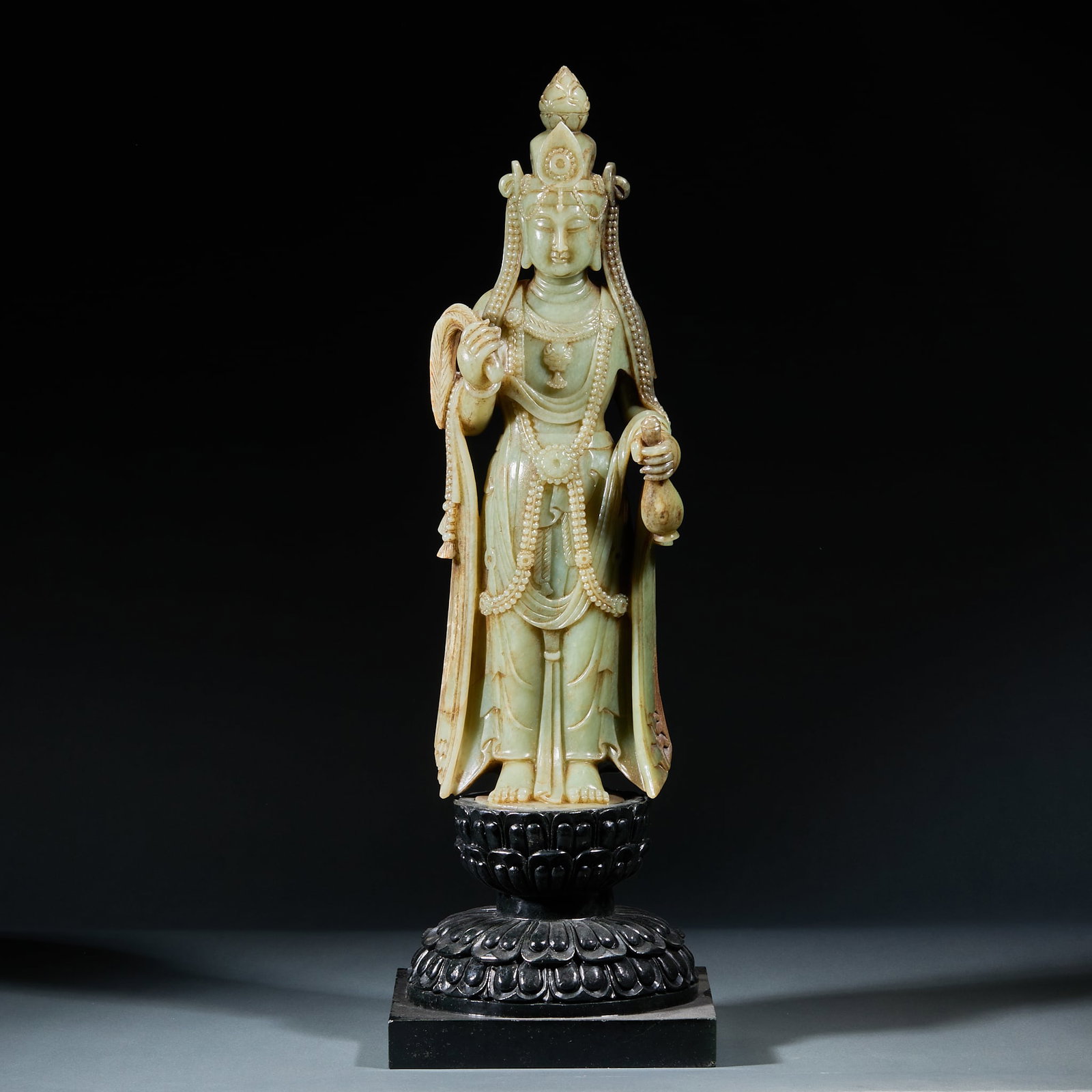 Hetian Jade Guanyin with Jasper Base: Hetian Jade Guanyin with Jasper Base: Hetian jade carved standing Guanyin with merciful facial features and flowing robe lines, matched with jasper lotus throne base, overall dignified grand demeanor.