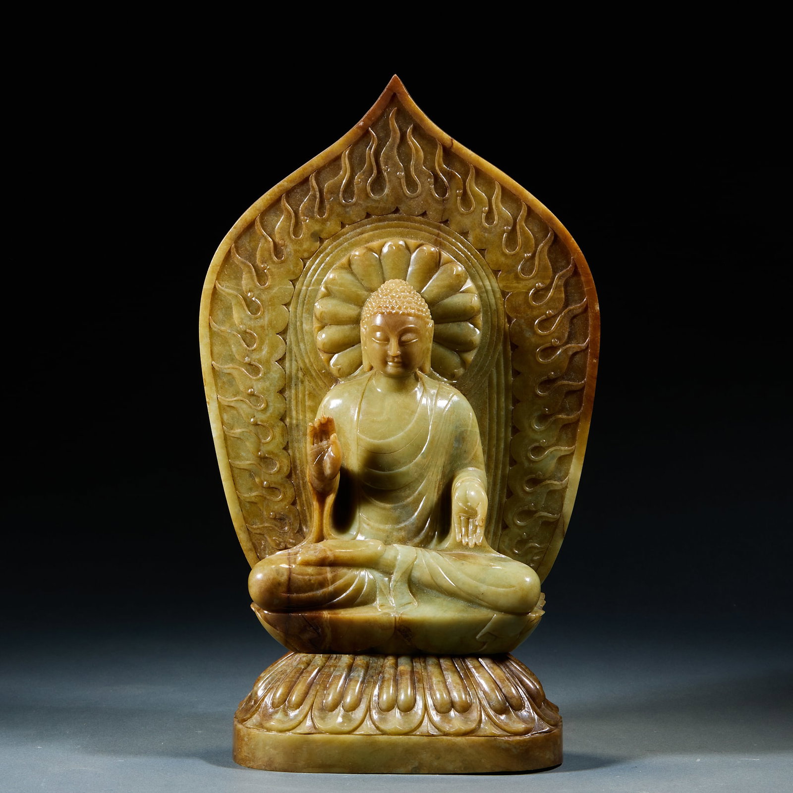 Hetian Jade Sakyamuni Buddha Statue: Hetian Jade Sakyamuni Buddha Statue: Mild fine Hetian jade carved seated Sakyamuni Buddha with flame-patterned nimbus backdrop and exquisite consummate craft. Height 35.5cm, length 17cm, width 10cm, w