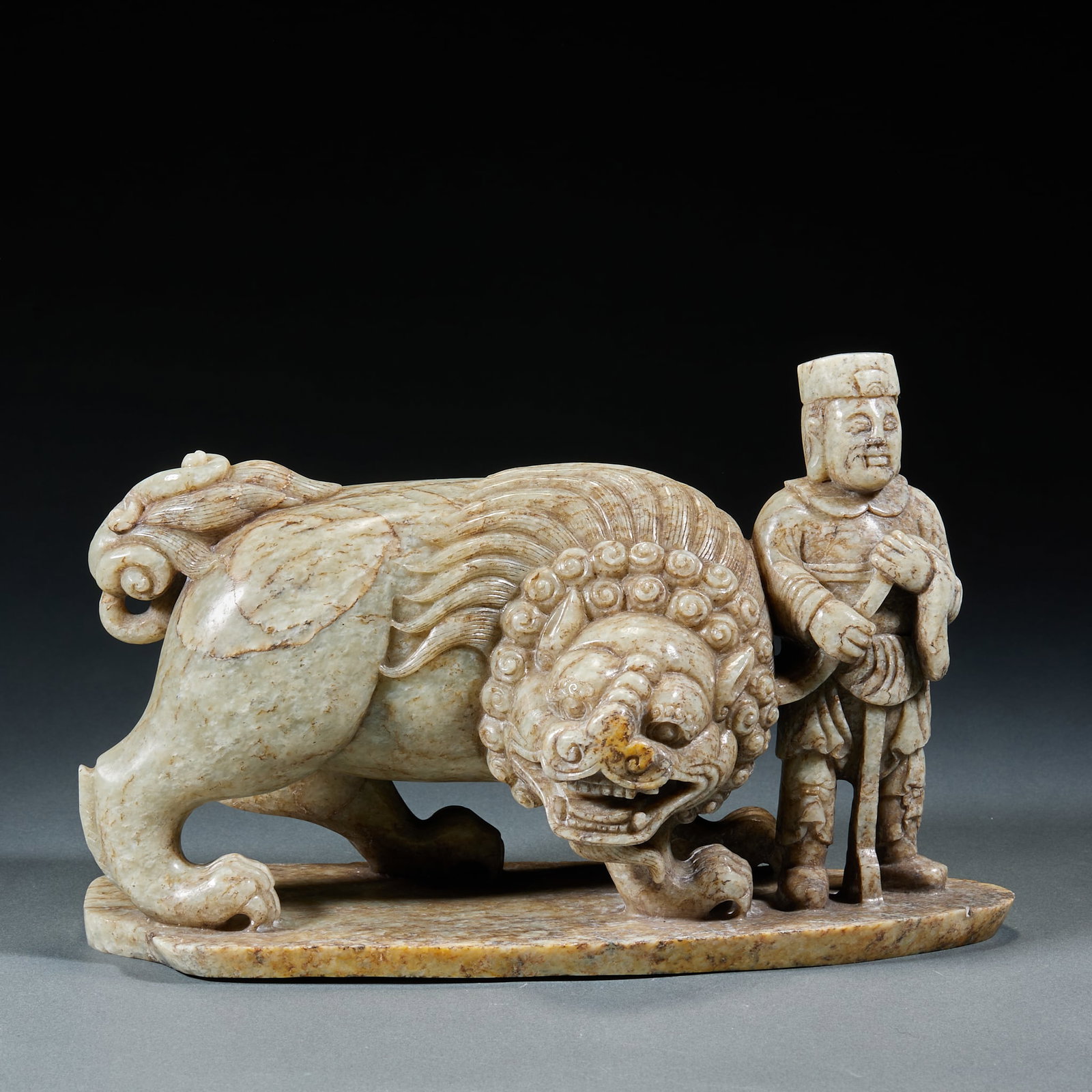 Hetian Jade Hu Taming Lion Ornament: Hetian Jade Hu Taming Lion Ornament: Mild fine Hetian jade carved with vivid lifelike scene of Hu ethnic figure taming lion, classic traditional theme. Height 16.5cm, length 26cm, width 9cm, weight 37