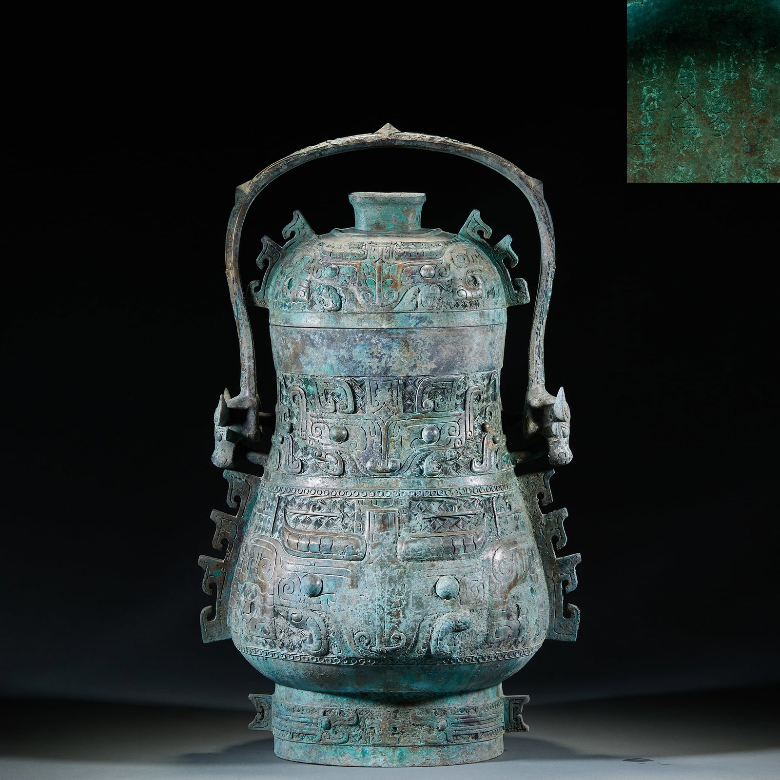 Western Zhou Bronze Lidded You Vessel: Western Zhou Bronze You with Handle: Cast in bronze with relief and line carving techniques, decorated with taotie patterns and cloud thunder patterns, designed with a movable handle adopting exquisit