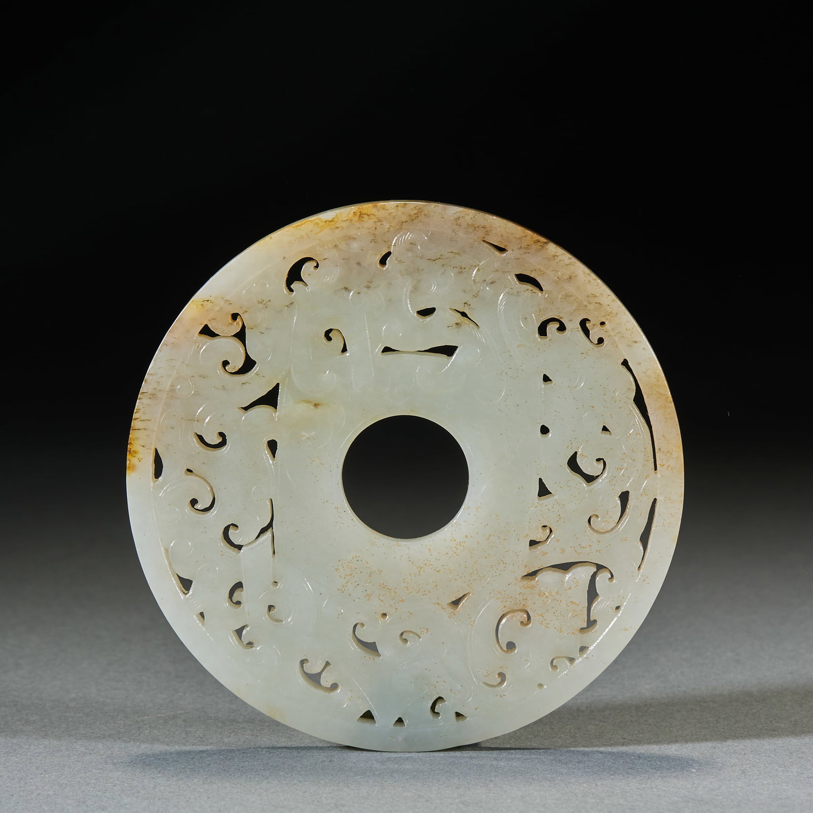 Jade Bi Disc: Jade Bi: Made of Hetian jade with openwork carved dragon patterns and natural aging mottling, mild texture; Diameter 9.5cm; A fine ancient jade bi with elaborate carving, complicated ornamentation and