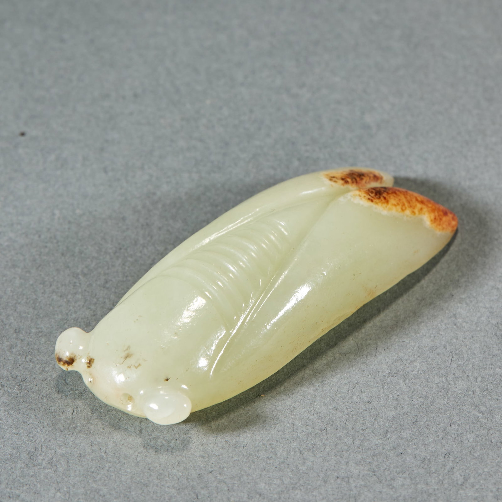 Hetian Jade Cicada Pendant: Hetian Jade Cicada-Shaped Pendant: Made of white Hetian jade with natural skin tone, carved into cicada shape with concise lines; Height 1.4cm, length 6.7cm, width 2.4cm, weight 43g; Symbolizing