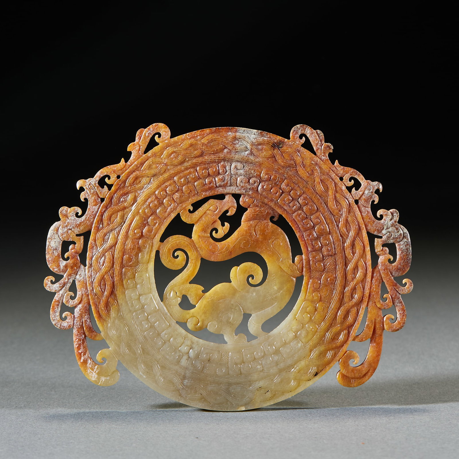 Pre-Ming Dragon Pattern Jade Bi Disc: Pre-Ming Dragon Pattern Jade Bi: Made of Hetian jade with natural mottling, openwork carved with complicated dragon patterns; Length 12.2cm, width 9.8cm; An ancient ritual jade bi with superb carving