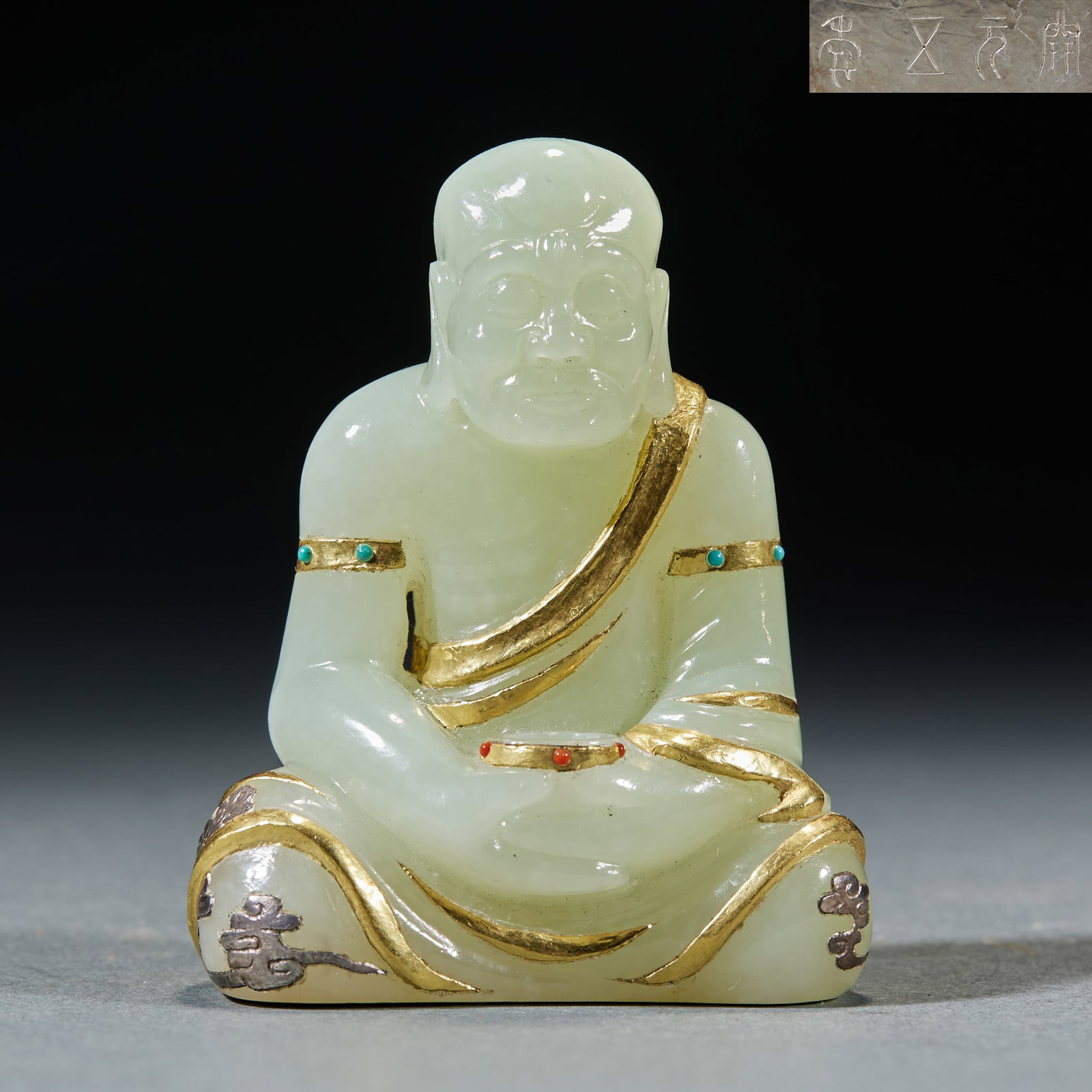 Gold Inlaid Jade Arhat: Gold-Inlaid Jade Arhat: Made of Hetian jade with gold inlay and turquoise decorated robe lines and serene expression; Height 6.5cm, length 5cm, width 3cm, weight 132g; A Buddhist-themed jade ornament 