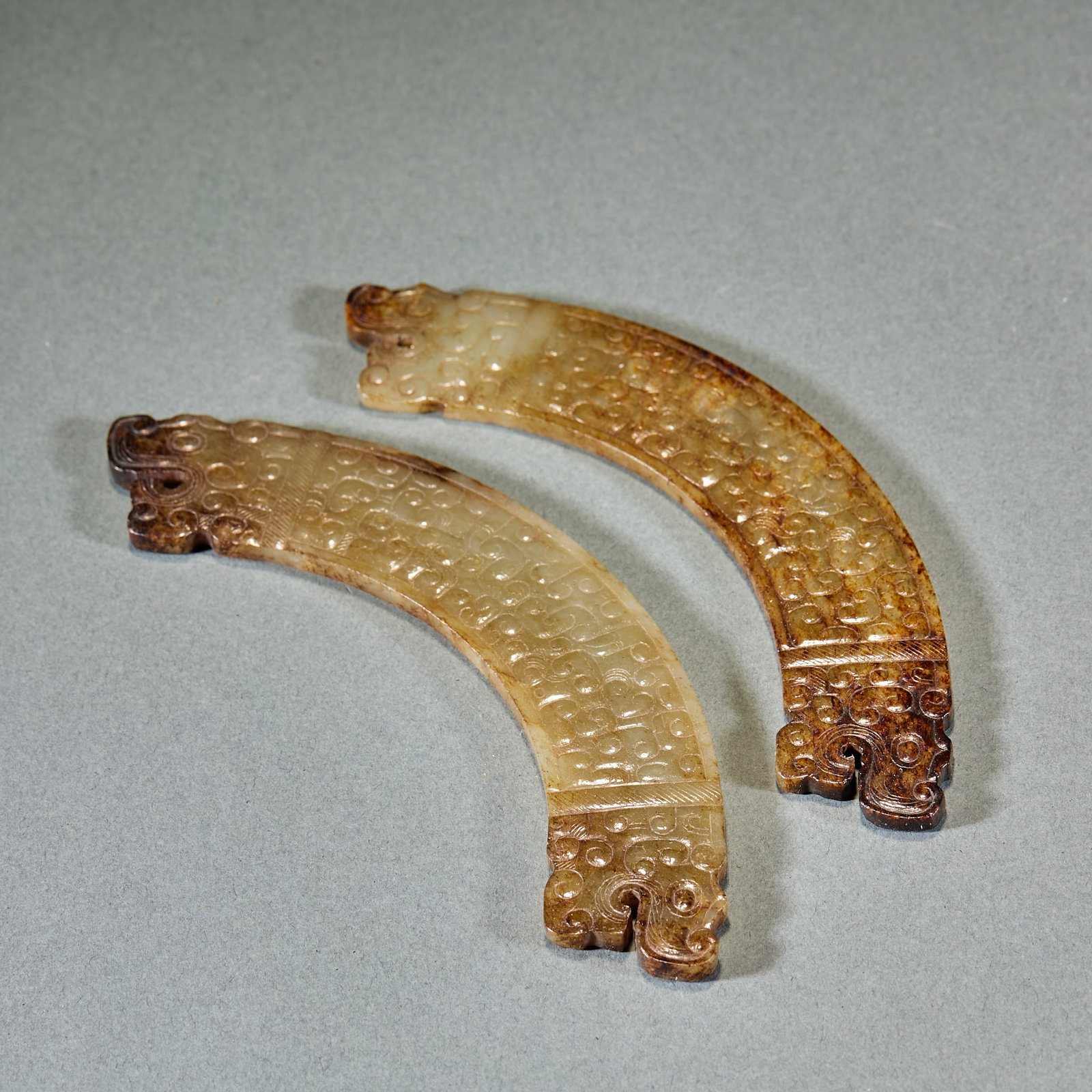 Warring States Double Dragon Head Cloud Pattern Jade Huang, A Pair: Pair of Warring States Double Dragon Head Cloud Scroll Jade Huang: Made of Hetian jade with red natural mottling, carved with dragon heads at both ends decorated with cloud scroll patterns, preserved 