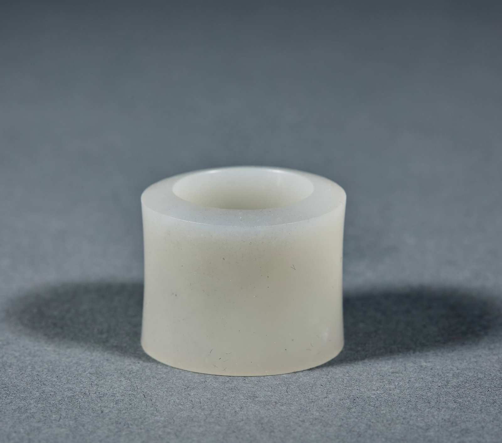 Hetian Jade Archer Ring: Hetian Jade Thumb Ring: Made of plain unpatterned Hetian jade with regular shape and pure jade quality; Height 2.5cm, diameter 3.1cm, weight 28g; A practical ancient jade ornament with mild texture,