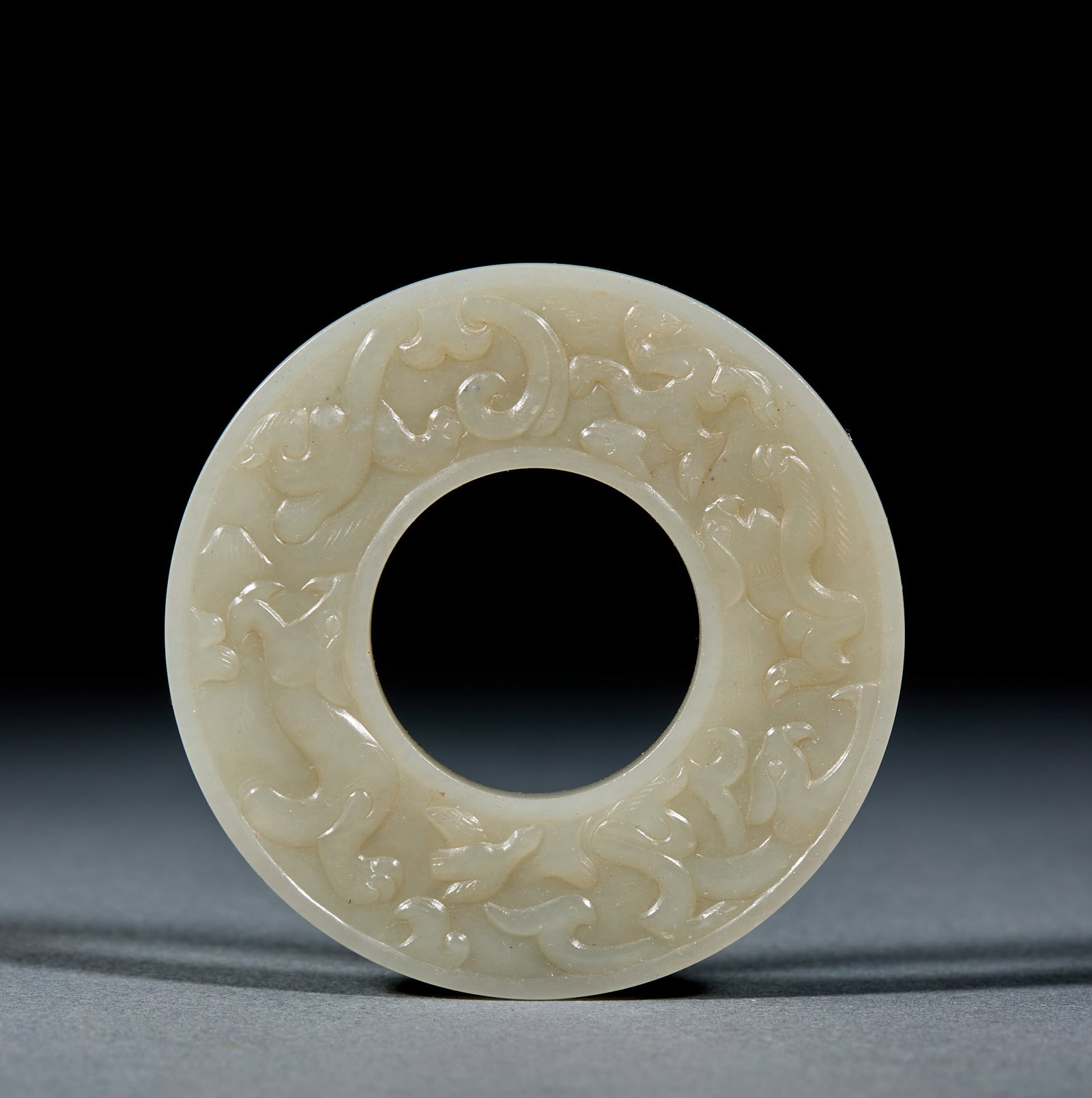 Hetian Jade Bi Disc: Hetian Jade Bi: Made of white Hetian jade shallow relief carved with mythical beast patterns and mild delicate texture; Diameter 7cm, weight 44g; Featuring fluent decorative lines, it serves as an anc