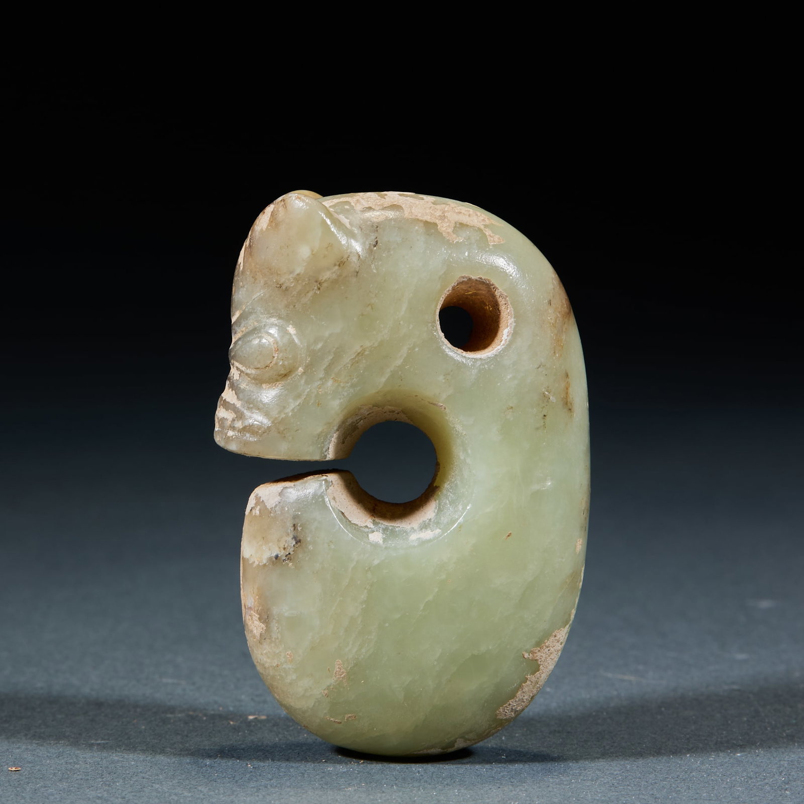 Hongshan Culture Pig Dragon: Hongshan Culture Pig Dragon: Made of blue-yellow jade with primitive elegant shape, being a typical artifact of Hongshan Culture; Length 6cm, width 4cm; Featuring mild jade texture and concise craft, 