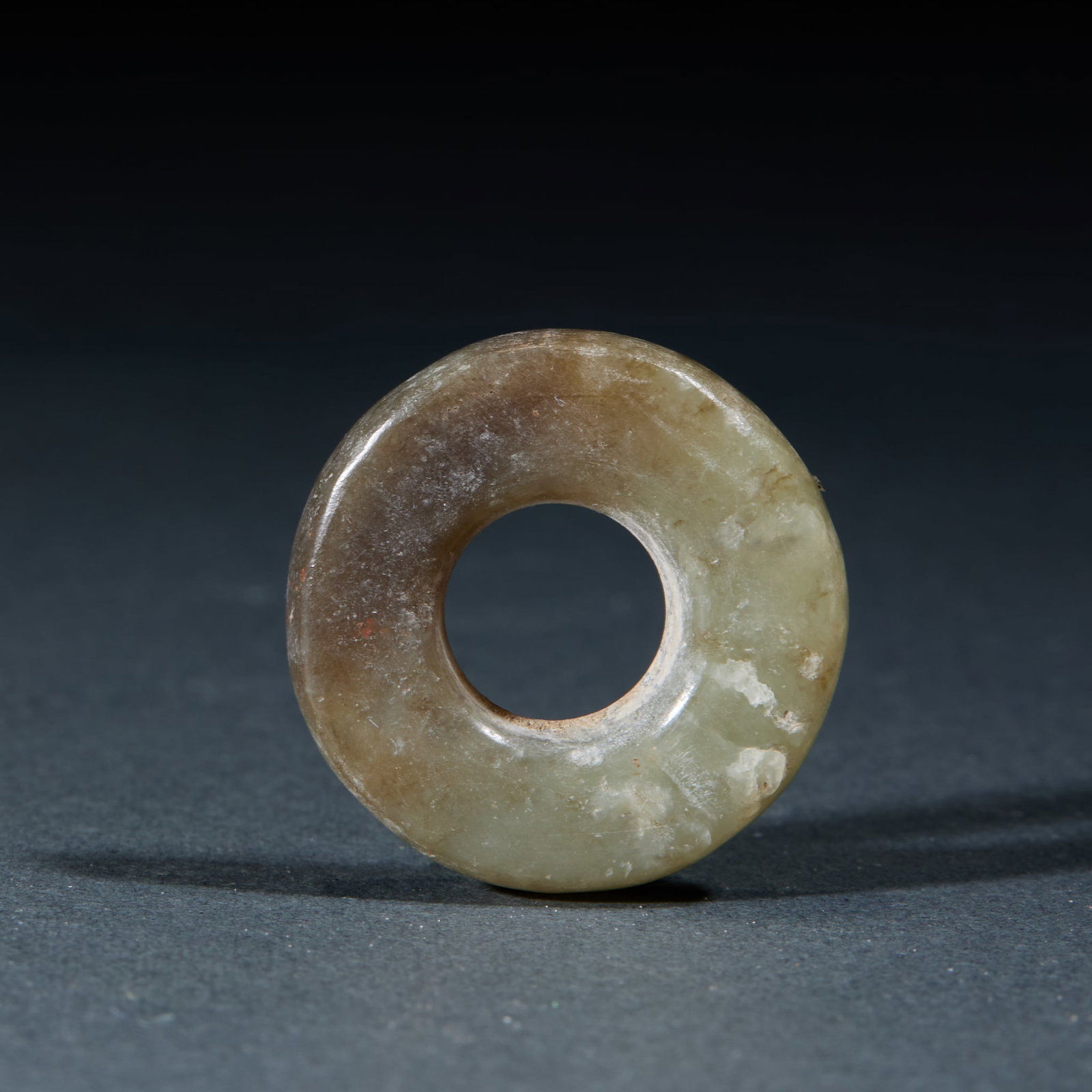 Hongshan Jade Ring: Hongshan Culture Jade Ring: Made of jade with natural mottling, perfectly round plain ring shape without decoration; Diameter 2.7cm, weight 8g; An ancient ritual jade ornament with fine texture and