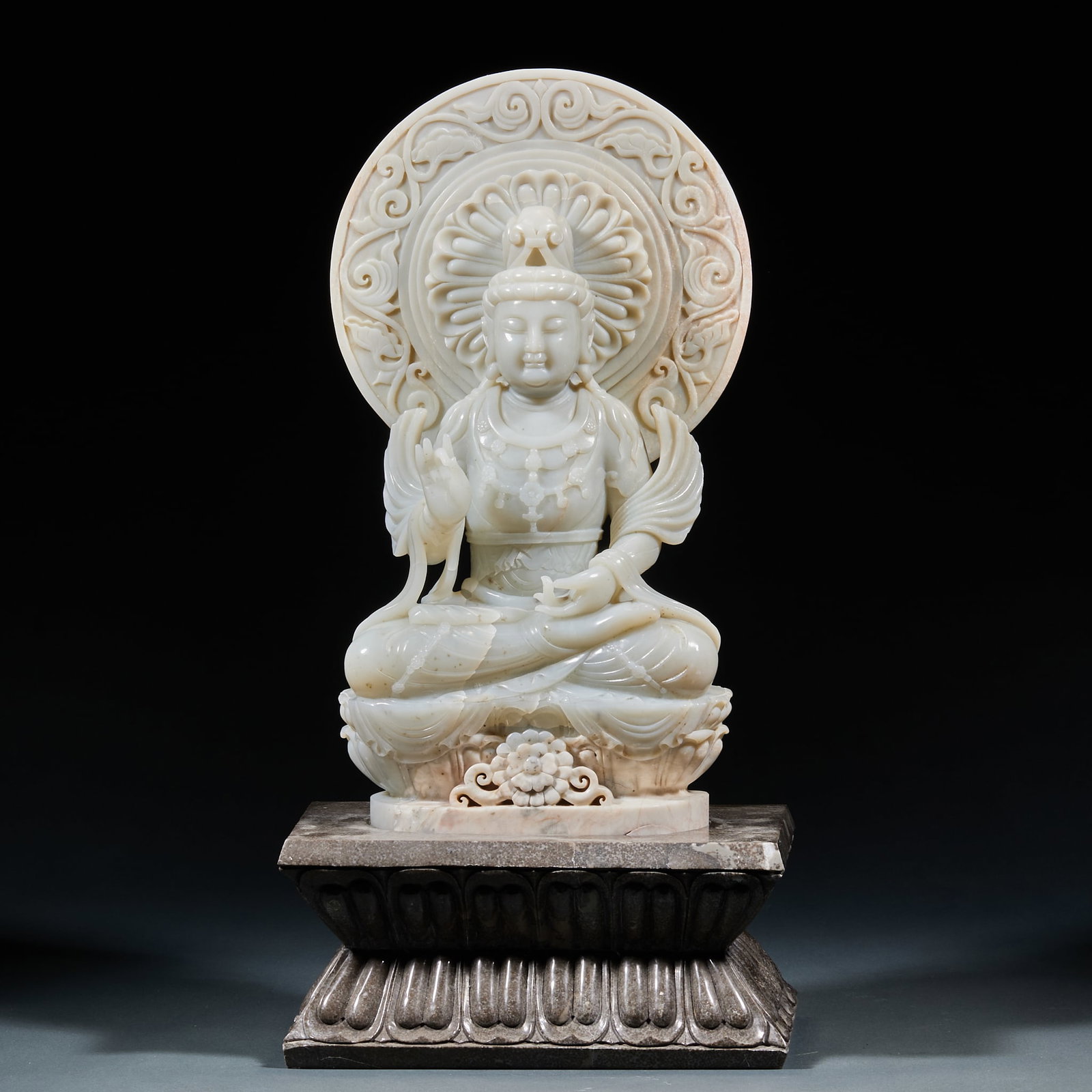 Seated Hetian Jade Guanyin with Jasper Base: Hetian Jade Guanyin Sitting Statue: Made of white Hetian jade carved with sitting Guanyin, matched with lotus backlight and base; Height 41cm, length 21cm, width 14cm; Benign facial expression, fluent