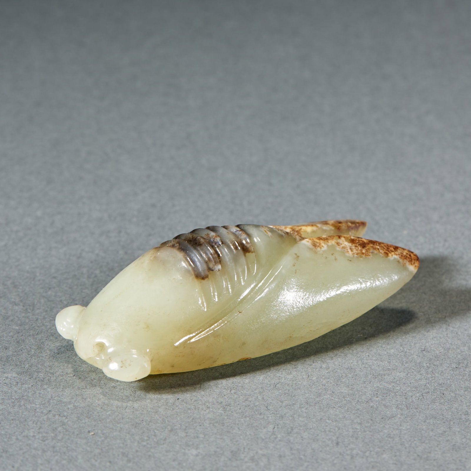 Hetian Jade Cicada: Hetian Jade Cicada: Made of white jade with red natural mottling, carved into lifelike cicada shape symbolizing noble integrity; Height 2.4cm, length 5.7cm, width 2.2cm, weight 36g; A refined Han Dyna