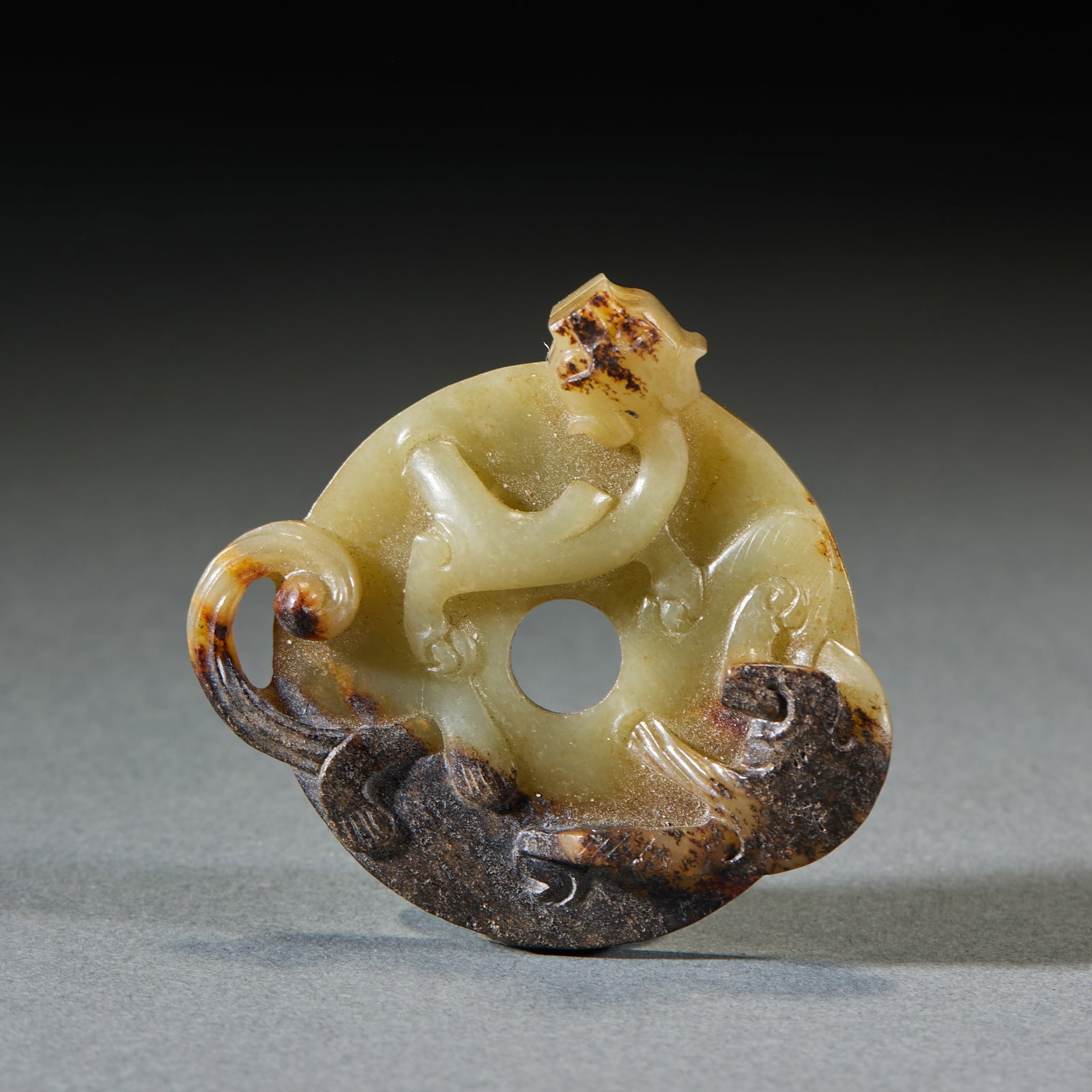Pre-Ming Chilong Jade Bi Disc: Pre-Ming Chilong Jade Bi: Made of jade with black natural mottling, relief carved with chilong patterns and mild jade texture; Height 1cm, diameter 5.6cm; Powerful chilong design makes it a valuable a