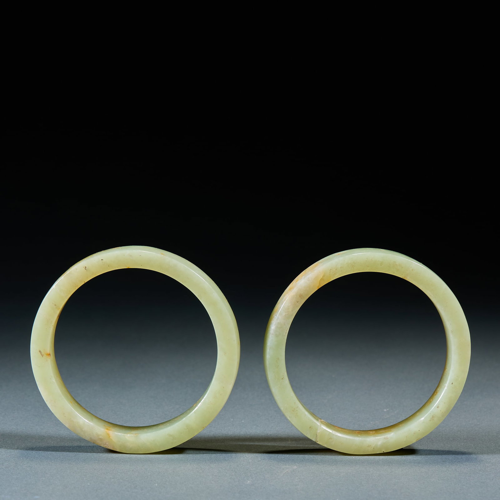Jade Bangle, A Pair: Pair of Jade Bangles: Made of jade with natural mottling in round bar shape and mild texture; Inner diameter 6.2cm, thickness 1.6cm, weight 164g; Primitive elegant color and well-preserved paired set 