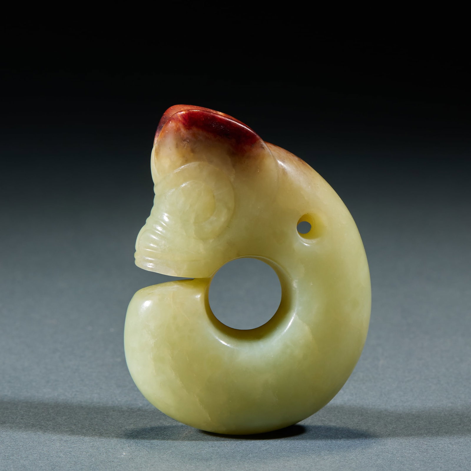 Hongshan Culture Jade Dragon: Hongshan Culture Jade Dragon: Made of jade with red mottling in classic C-shape, a typical artifact of Hongshan Culture; Length 7cm, width 5cm, weight 129g; Primitive modeling and concise craft make i