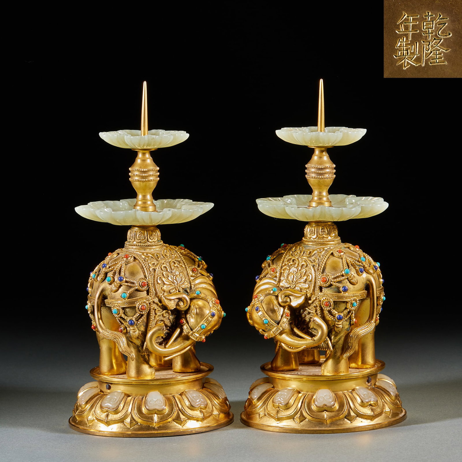 Qianlong Mark Gilt Bronze Jade and Gem Inlaid Peace Elephant Candlestick, A Pair: Pair of Qianlong Mark Gilt Bronze Jade and Gem Inlaid Peace Elephant Candlesticks: Gilt bronze main body shaped like an elephant, fully chiseled with interlocking patterns and inlaid with red, blue, g