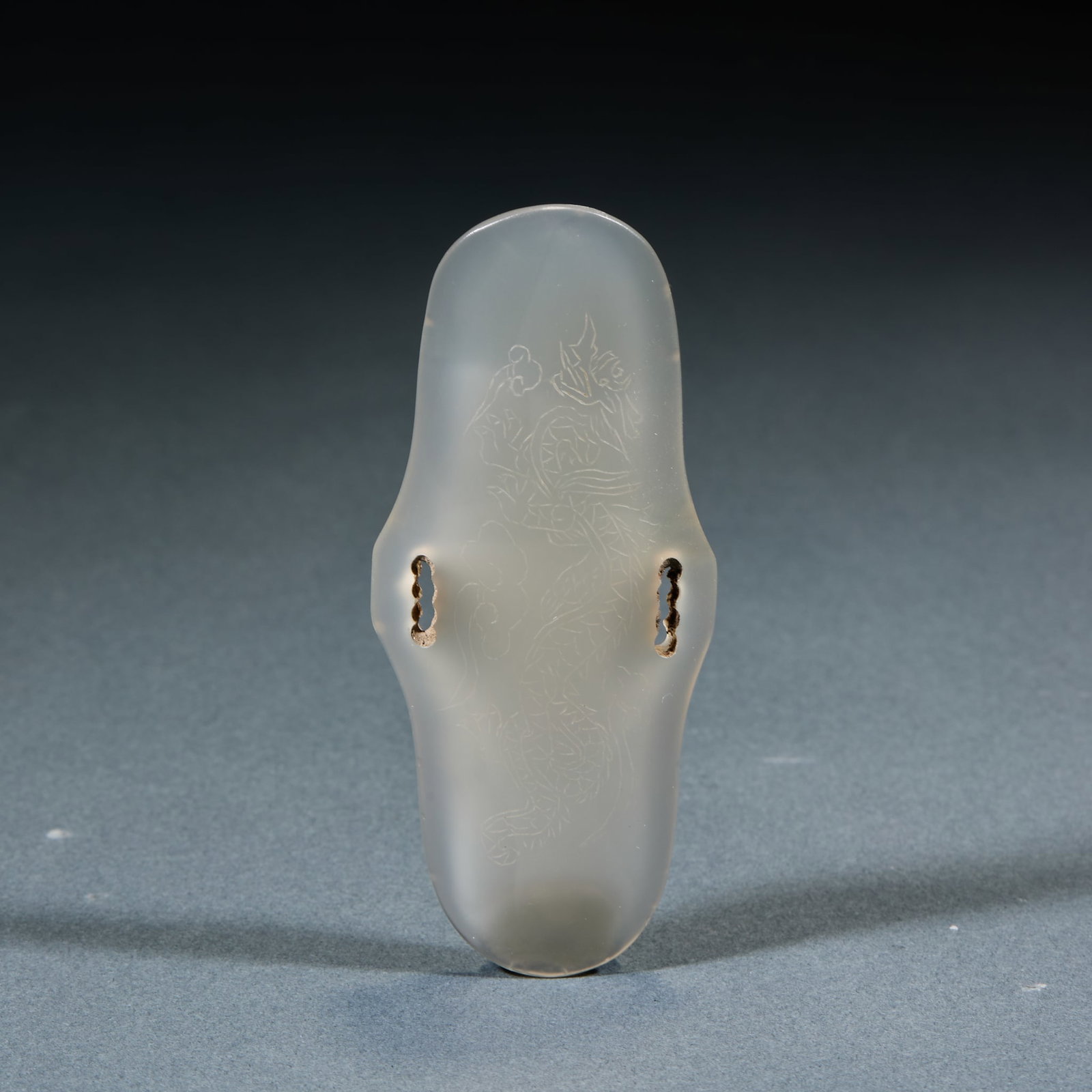 Agate Arm Guard: Agate Arm Guard: Made of agate in arc sheet form, body engraved with hidden dragon patterns and perforated on both sides; Length 8.5cm, width 3.5cm; An ancient hunting utensil with mild texture and