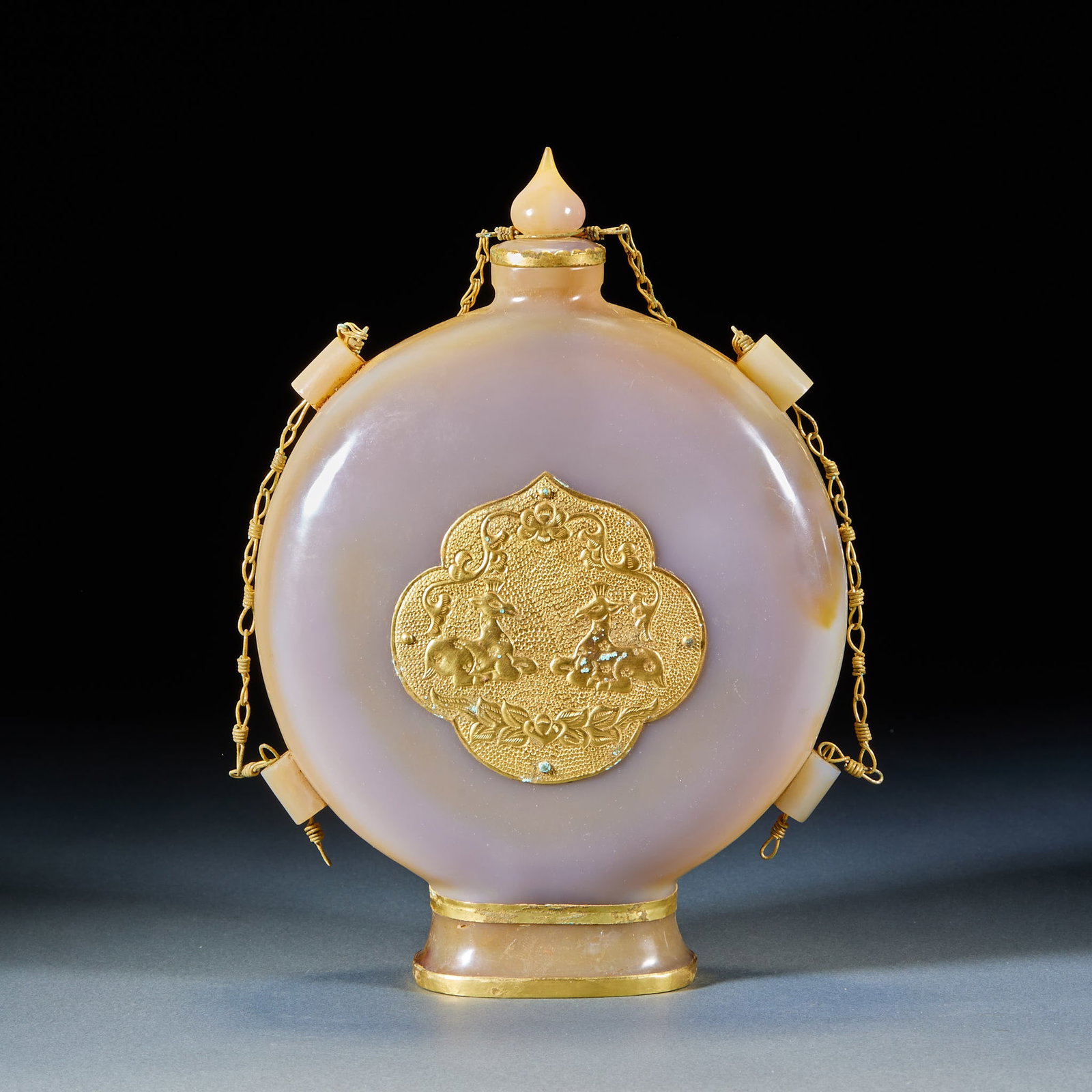 Agate Flat Vase, Pre-Ming Period: Gilt Agate Flat Flask with Double Deer Patterns, Pre-Ming Period. Hollowed and polished integrally from natural pale pink agate, the body is affixed with gilt chiseled double deer ruyi cartouche ornam