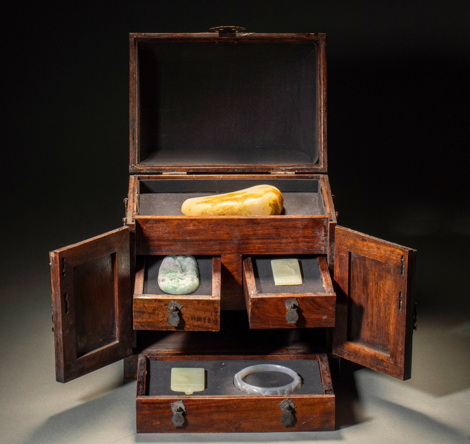 Treasure Chest with Jadeite and Jade Bracelets, Qianlong Period, Qing Dynasty: Huanghuali Multi-Grid Treasure Storage Box with Complete Set of Jade and Jadeite Wares, Qing Dynasty. The box stores layered Hetian jade rough stones, floating green jadeite landscape plaques and whit