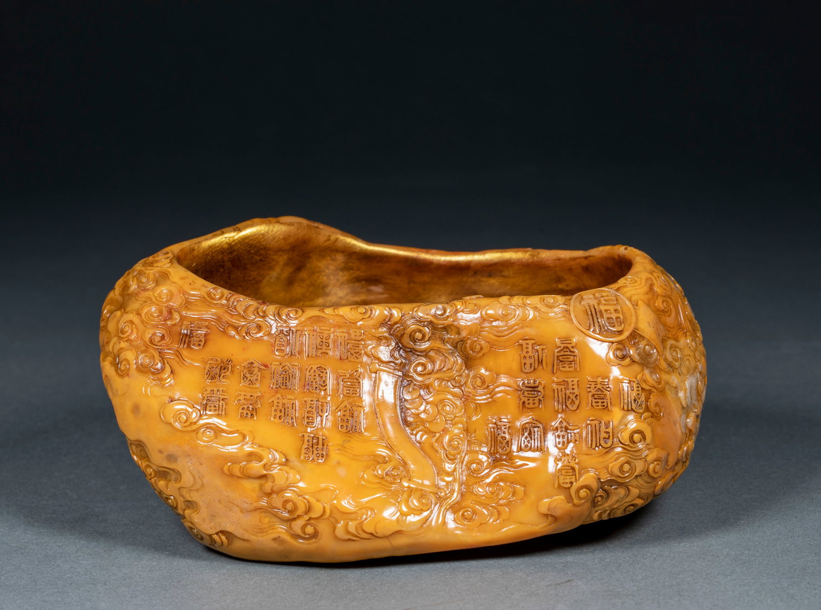 Tianhuang Stone Brush Washer with Gold-Outlined Hundred Blessings Pattern: Tianhuang Stone Brush Washer with Gold-Outlined Hundred Blessings and Auspicious Cloud Pattern. Carved following natural tianhuang stone shape, outer wall fully relief carved with seal script cloud an