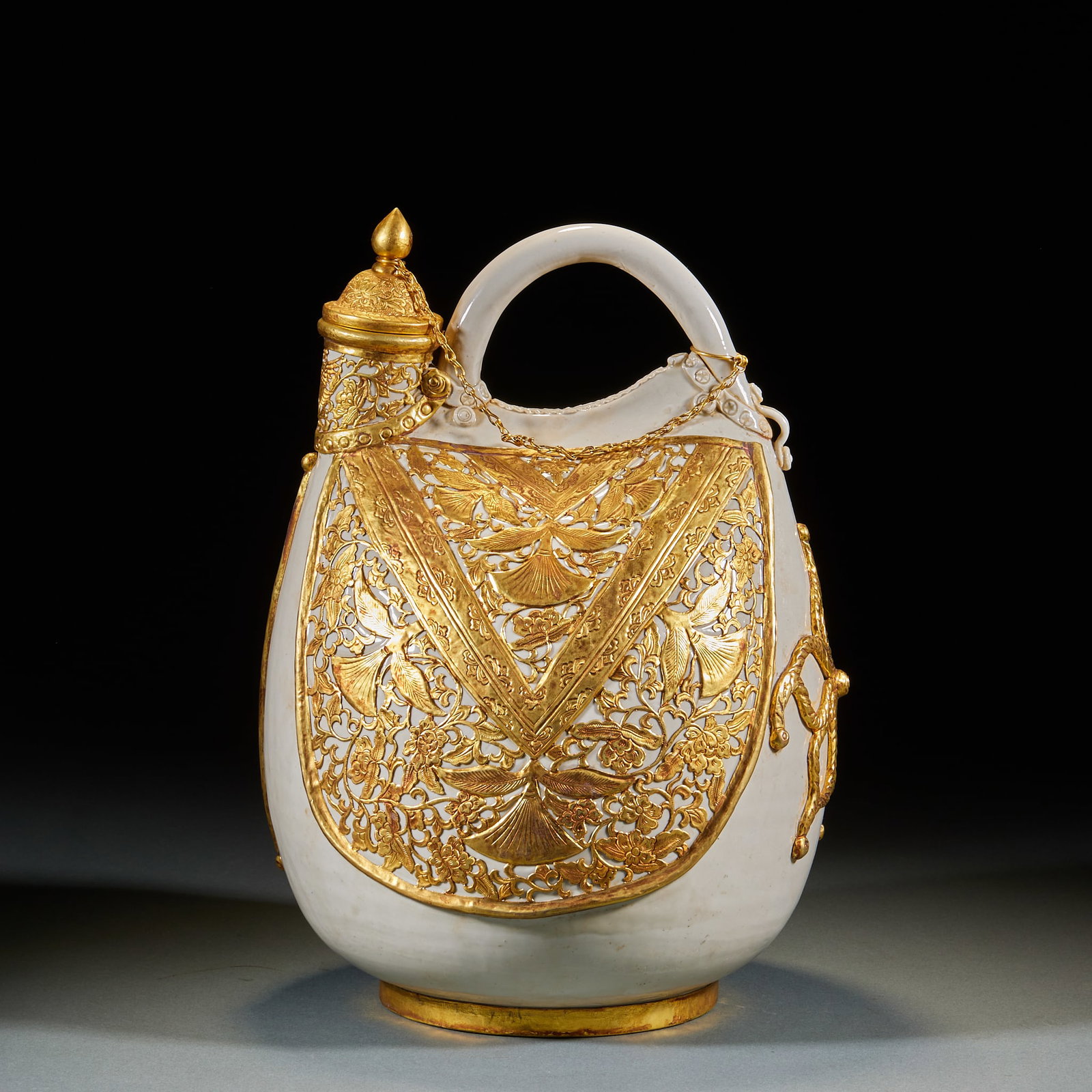 Ding Kiln White-Glazed Leather-Pouch Ewer with Flower-and-Bird Motif and Metal-Bound Rim: Ding Kiln White Glaze Leather-Shaped Flask with Gold-Wrapped Flower and Bird Motifs, of porcelain body with pure white glaze, imitating the leather vessel form of northern nomadic peoples, with arched