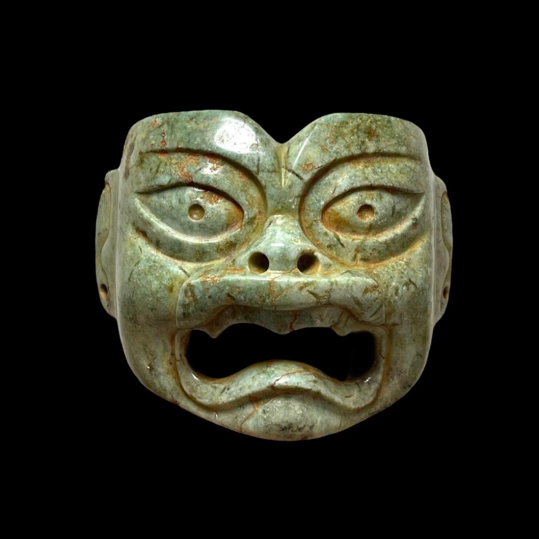 Pre-Columbian Olmec Jade jaguar mask: Pre-Columbian Olmec jaguar mask, Mexico, ca. 900-600 BC. Light green colored jade mask carved in the form of a were-jaguar. 4"x4.7"