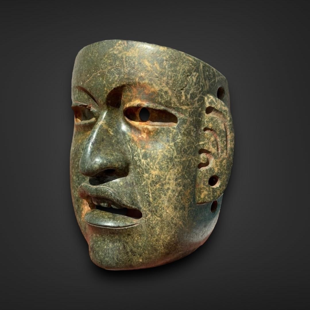 Pre-Columbian Olmec seroentine mask: Mexico, circa 900-600 BC. Olmec serpentine mask, exemplifying the ancient Olmec civilization's masterful artistry and their deep spiritual beliefs. The mask, carved from a dark green serpentine stone,