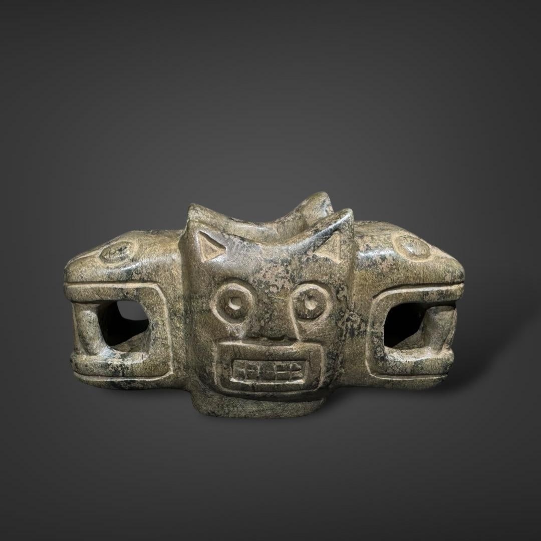 Pre-Columbian Chavin stone mace head: Pre-Columbian Chavín stone mace head, likely from ancient Peru, showcases the distinctive style and symbolism of the Chavín culture (circa 900–200 BCE). Crafted from dark green stone with a smooth