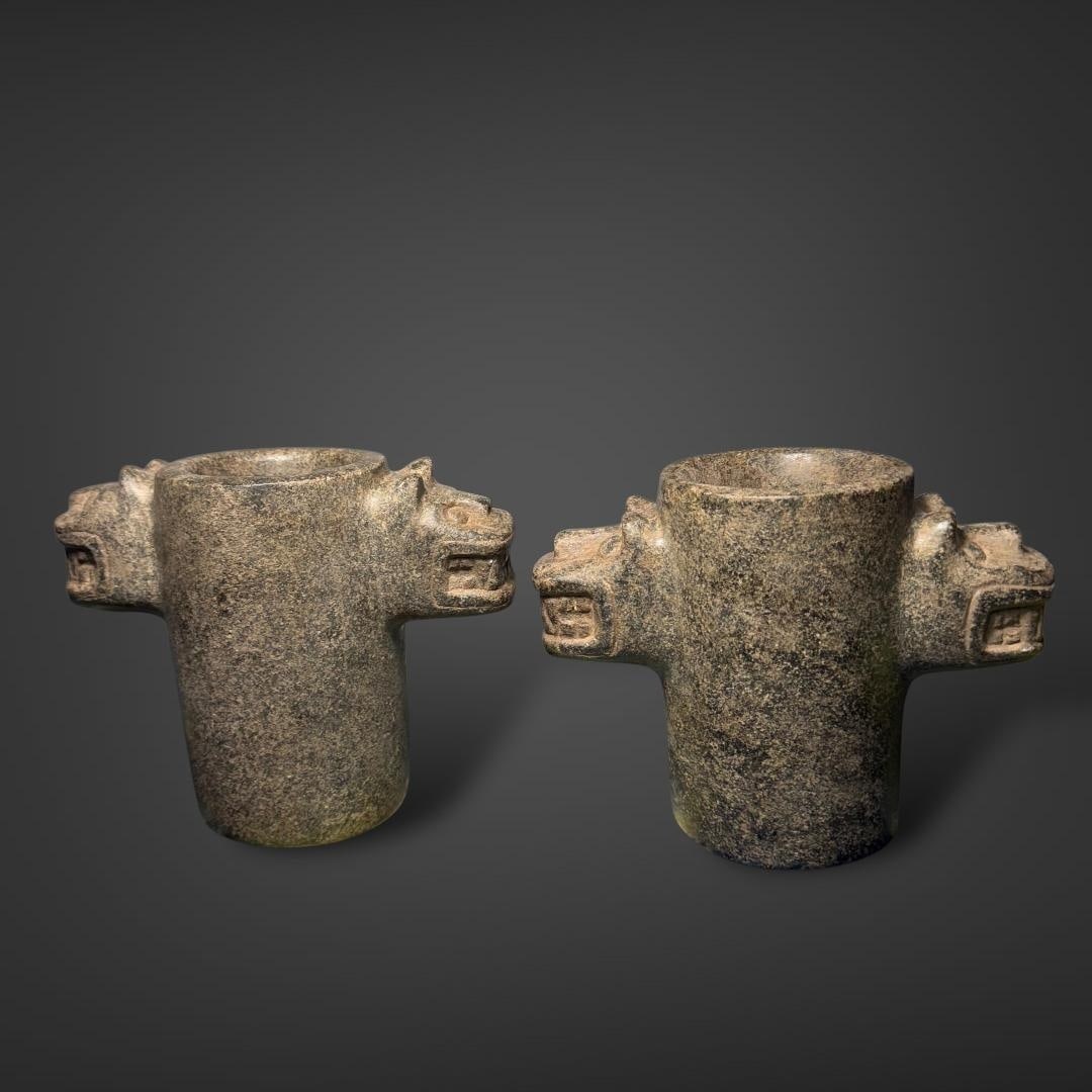 Pair of Pre-Columbian Chavin stone keros: An impressive pair of Pre-Columbian Chavín stone keros, dating to the Early Horizon Period (900-500 BCE), attributed to the Chavín culture of ancient Peru. Each vessel is cylindrical in form and mas