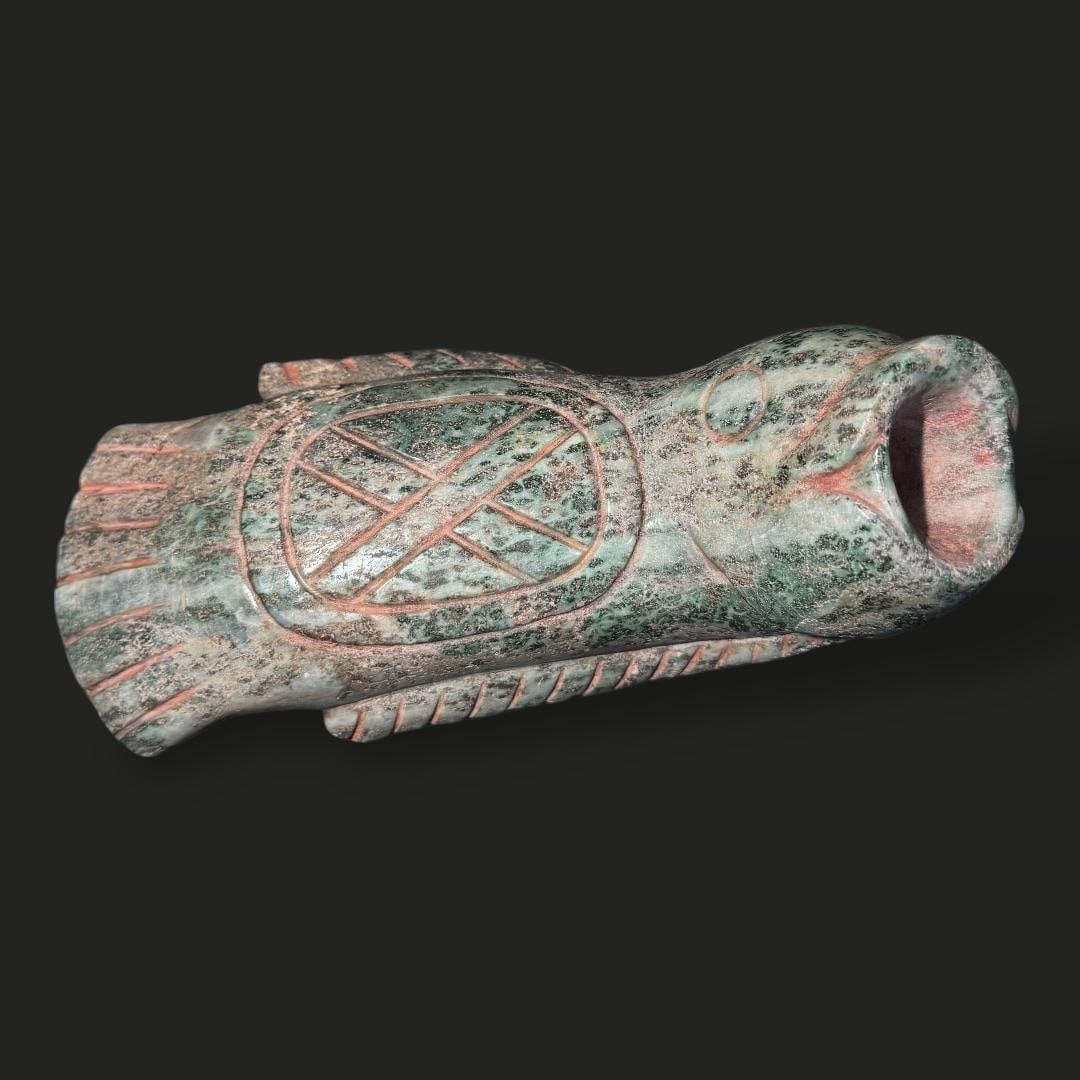 Pre-Columbian Olmec green stone fish vessel: Pre-Columbian Olmec green stone fish vessel is a finely carved artifact that reflects the sophisticated craftsmanship of early Mesoamerican cultures. The vessel is sculpted in the form of a stylized f