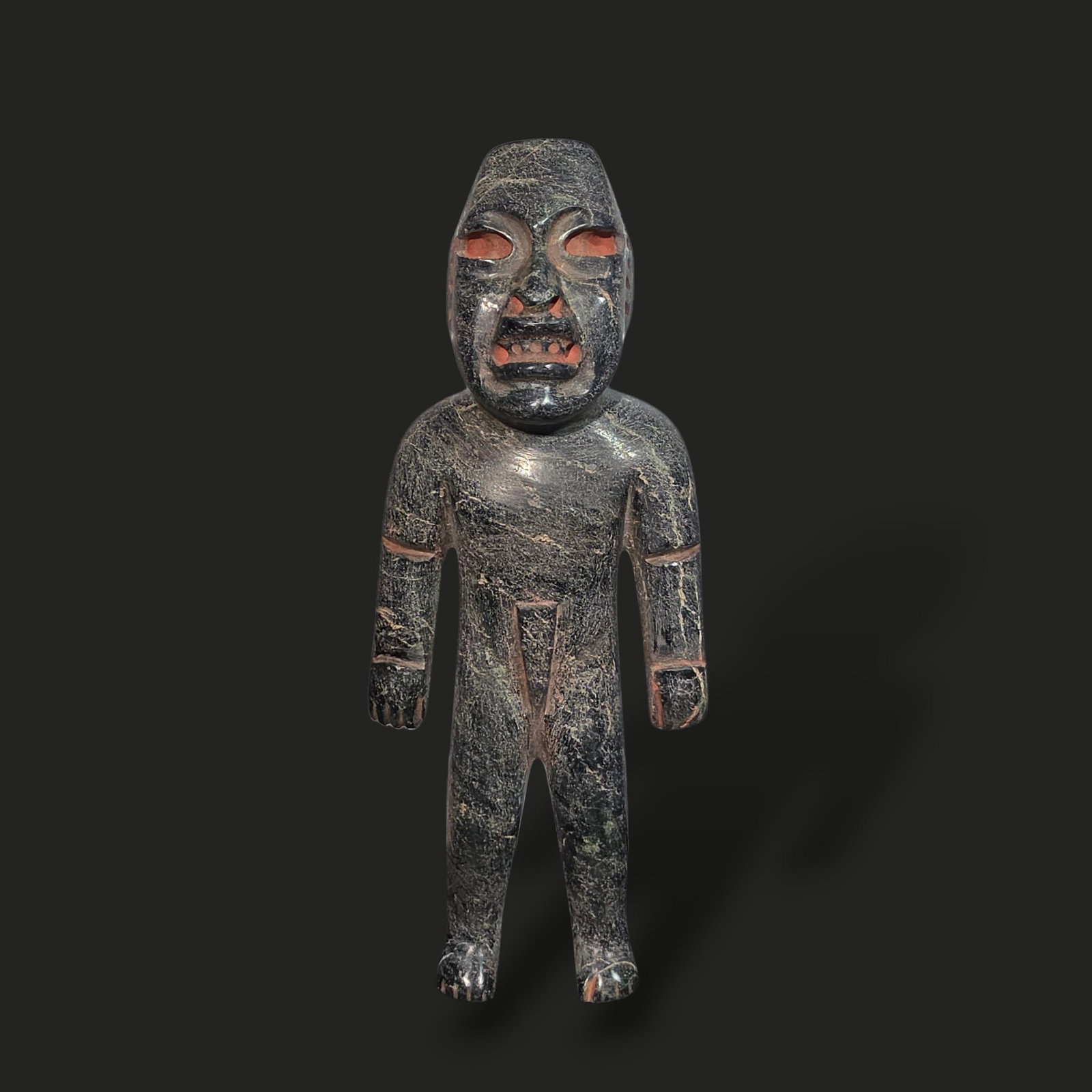 Pre-Columbian Olmec serpentine figure: Pre-Columbian Olmec serpentine figure is an extraordinary representation of Olmec craftsmanship and spiritual iconography. Carved from a deep green serpentine stone with natural veins of red and ochre