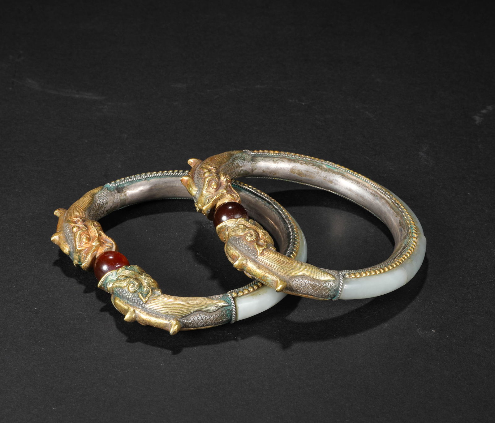 A pair of silver and gilded bracelets wrapped in jade from the 10th century (1 of 7)