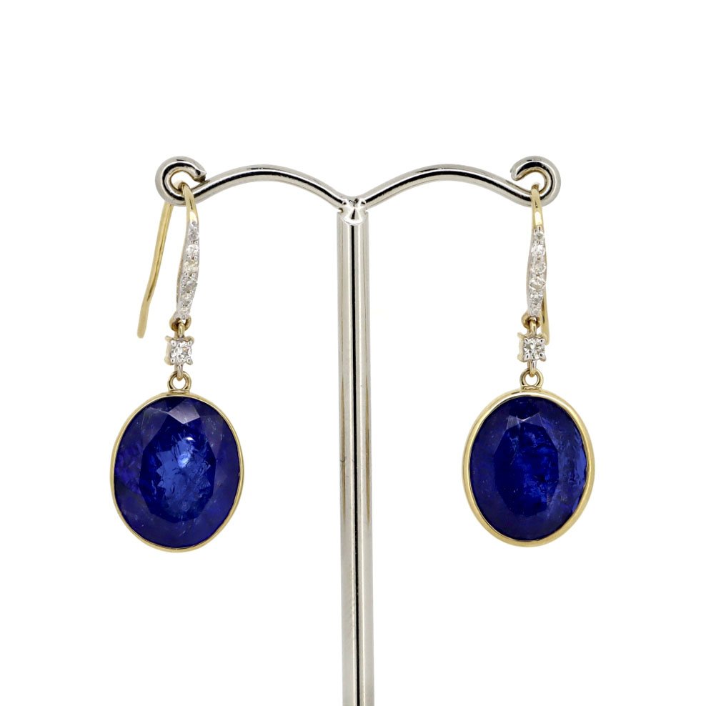 14CT Yellow Gold Tanzanite And Diamond Earrings: A 14ct yellow gold Tanzanite and diamond earrings. Features two oval cut Bluish Purple Tanzanites at 18.49ct total carat weight and fourteen round brilliant cut diamonds at 0.18ct total diamond weight