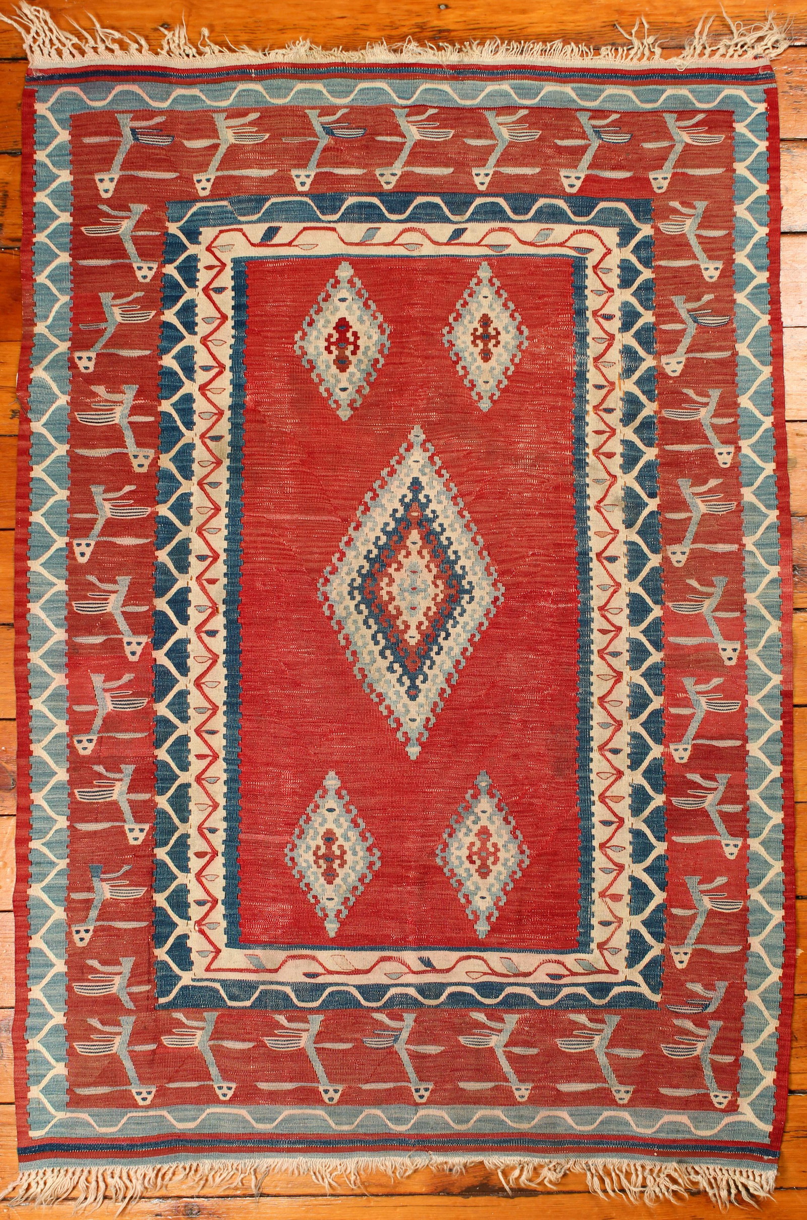 Turkish Kilim Rug: Type: Rug Materials: Dyed wool Markings & Inscriptions: Unmarked Date: Mid 20th century Maker: Turkish Description: A Kilim area rug decorated with bird-like figures and geometric motifs. Dimensions: 
