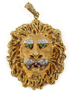 Diamond, Ruby, and Emerald 18K Yellow Gold Lion's Head Pendant Brooch: Description: A Hammerman Brothers style 18K yellow gold lion's head brooch with two emerald eyes and a ruby set mouth, also set with approximately 1/2 carat in diamonds. Type: Pendant, brooch