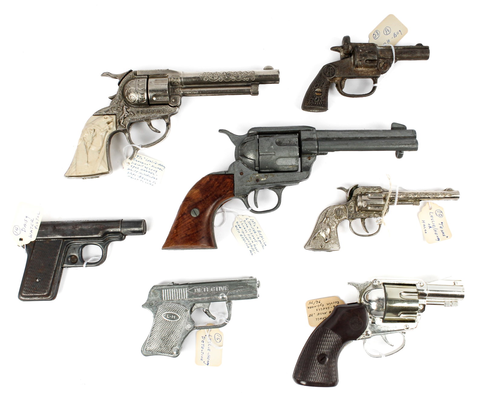 Seven Vintage Toy Guns Incl. Daisy, Leslie-Henry Champion, Mattel, etc.: Description: A collection of seven vintage toy guns, all metal, to include: three Leslie-Henry pistols - Texas, Detective and Champion (tooled nickel and long spur hammer), a Mattel Shootin' Shell snu