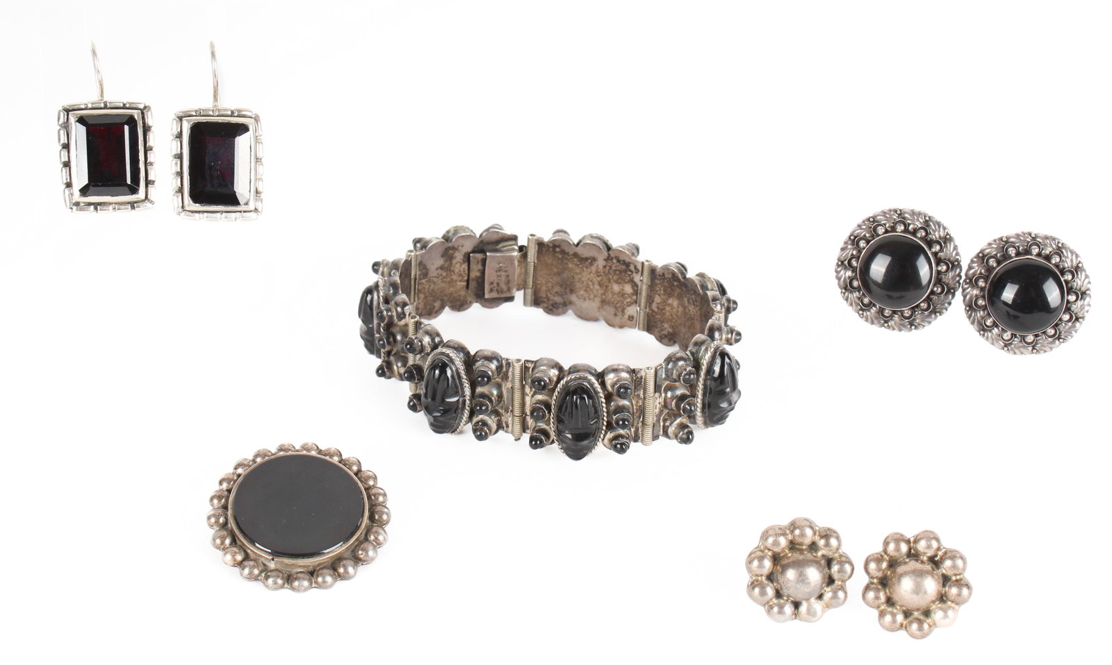 Silver Earrings, a Bracelet, and a Brooch, Including Carved Onyx: Description: An assortment of silver jewelry comprised of a carved onyx bracelet, three pairs of earrings and a brooch. Type: Bracelet, earrings (perced and clip-on), brooch Materials: Silver, onyx Ma