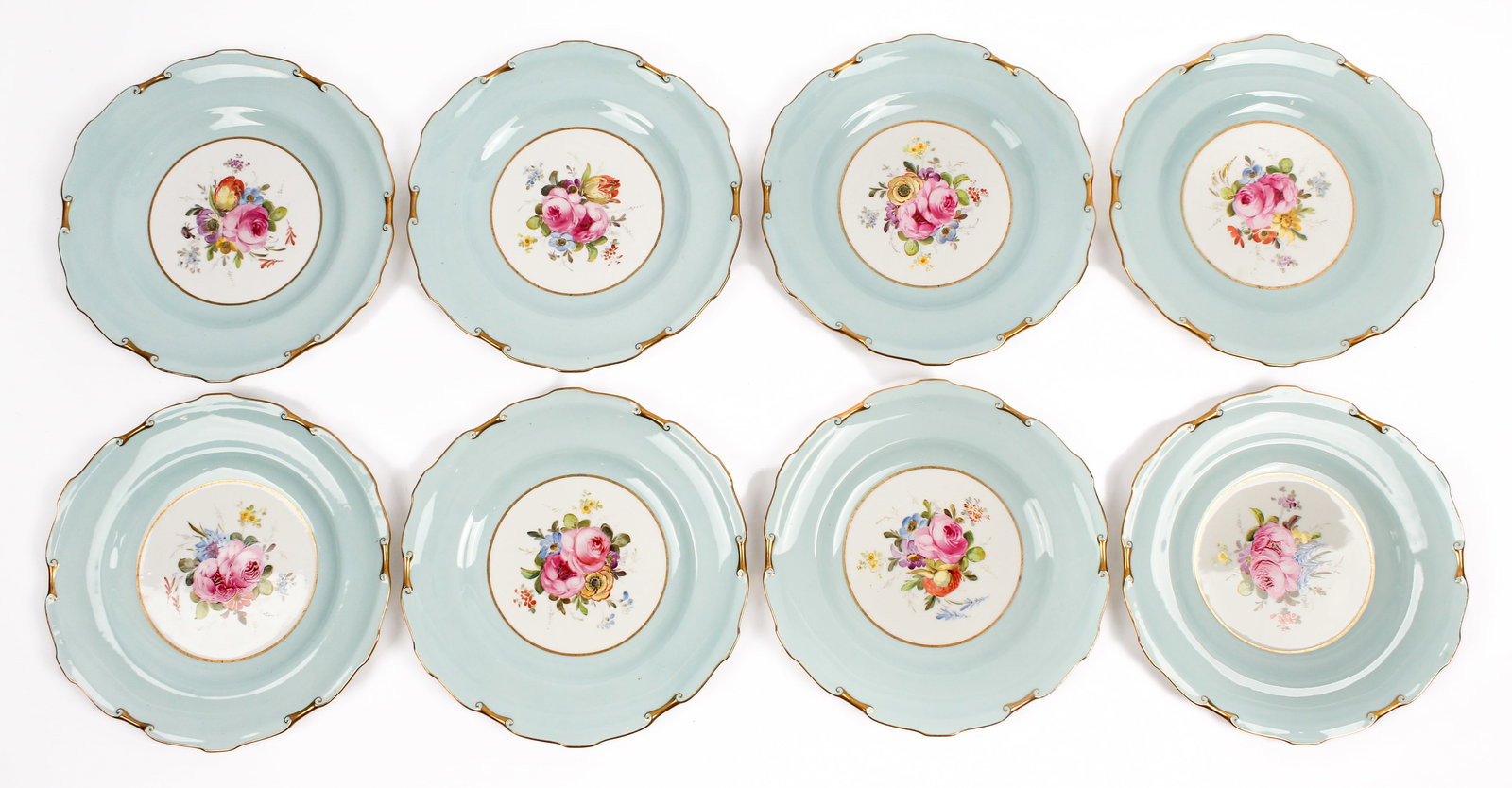 Eight Royal Crown Derby Floral Porcelain Cabinet Plates, Cuthbert Gresley: Description: A group of eight Royal Crown Derby hand painted porcelain cabinet plates with central floral decoration on a white and pastel blue ground and having a gilt and molded rim, signed by the p