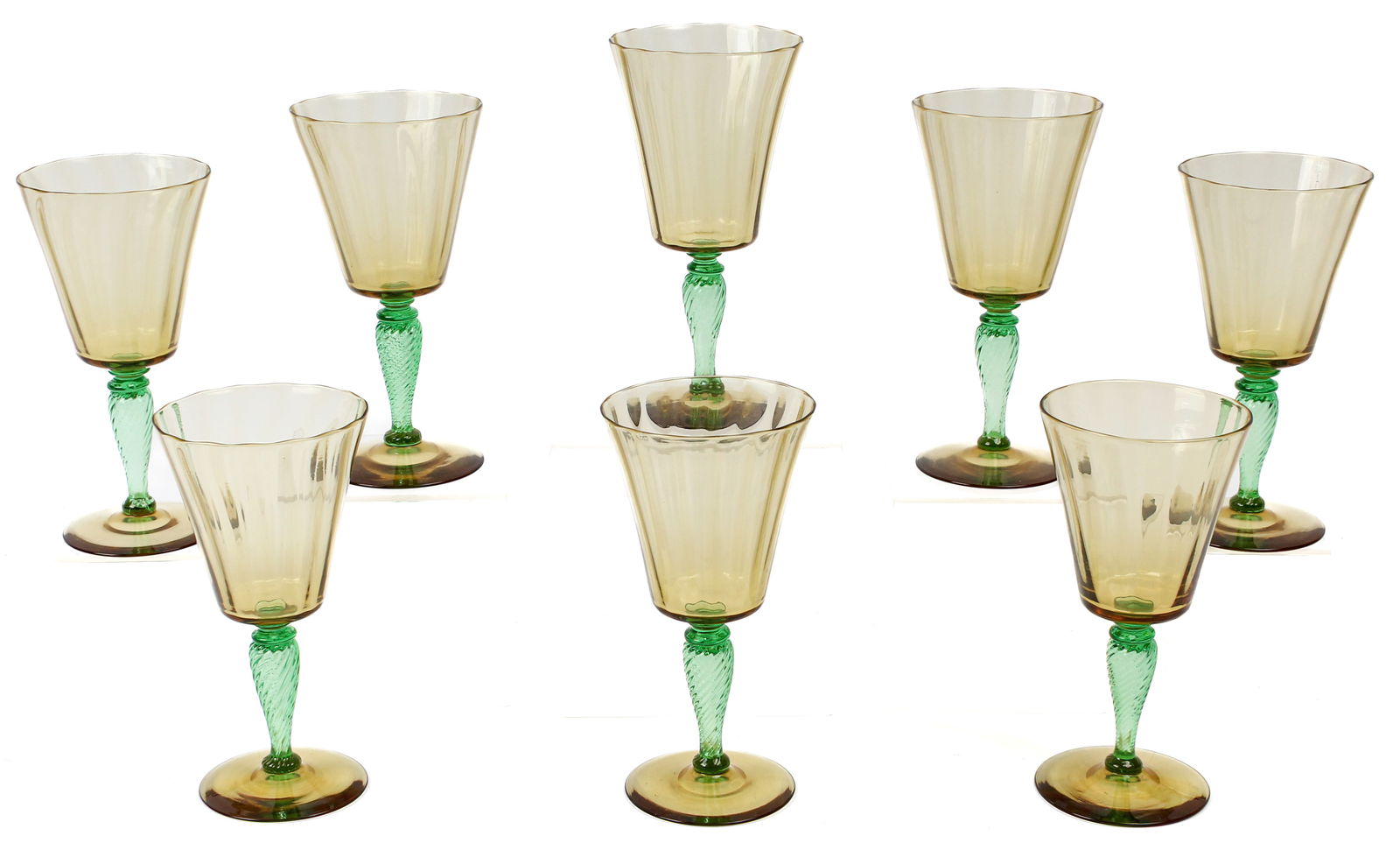 Carder Steuben Glass Amber Transparent Goblets: Description: A group of eight Steuben glass goblets, amber transparent colorway with pamona green stem, shape 3551, with vertical optic ribbing / paneling. Markings & Inscriptions: Most with acid stam