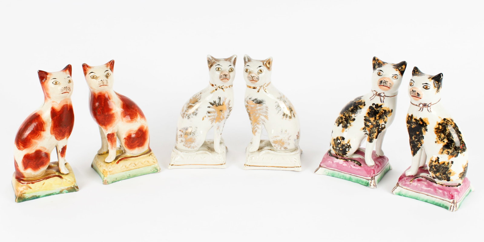 Six Victorian Staffordshire Seated Cat Figures: Description: Three pairs of seated Staffordshire hand painted cats. All likely from early to mid 19th century due to painting details, weight, and lack of makers' marks. One pair is white sponged with