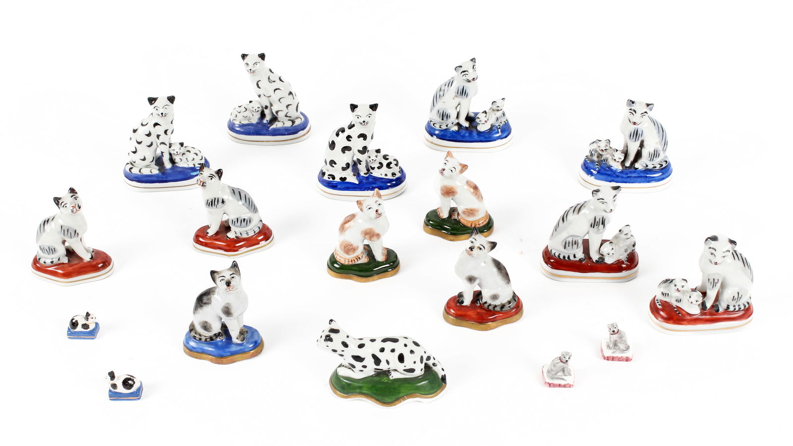 Chelsea Style Glazed Porcelain Figurines of Cats and Cats with Kittens: Description: Nine glazed porcelain Chelsea style marked figurines of seated cats and cats with kittens. Together with a pair of Sitzendorf porcelain seated cats on green pillows, an unmarked, spotted