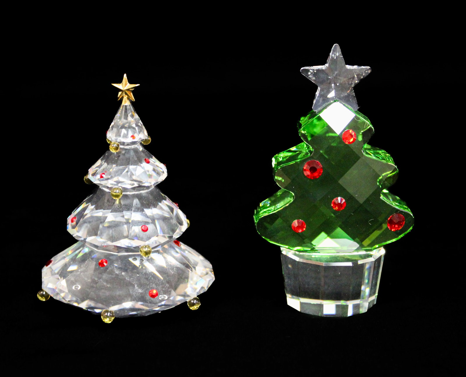 Two Swarovski Crystal Christmas Trees: Description: Two Swarovski crystal Christmas trees, including NR000606, a clear crystal tree with amber and red ornaments and a gold star, in its original box, and NR000109, a 'Felix the Christmas Tre