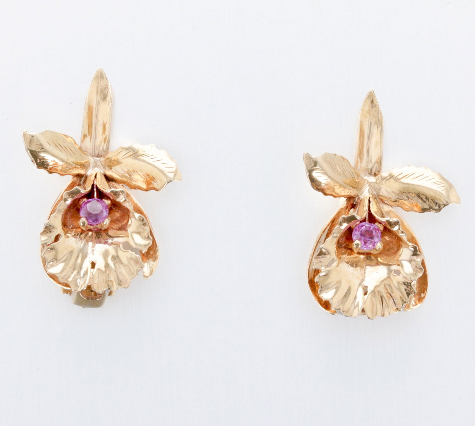 14K Gold and Pink Sapphire Ear Clips: Description: A 14K gold pair of clip earrings, each set with one round pink sapphire. Markings & Inscriptions: "14K", maker's mark: "C.D.L" Date: Mid-20th Century Maker: Carl D. Lindstrom Dimensions: 