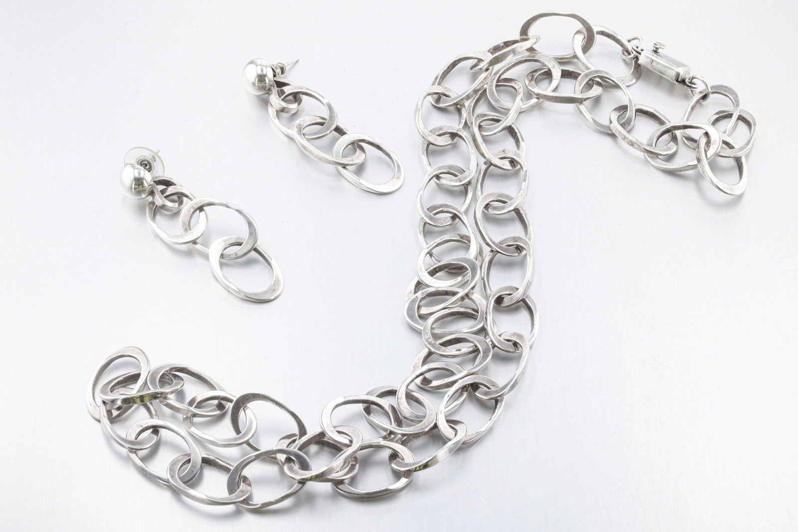 Mexican Sterling Silver Jewelry Set: Description: A sterling silver jewelry set consisting of one oval link chain and one pair of matching earrings. Markings & Inscriptions: "Mexico 925" Date: 1980-1990's Maker: Unknown, Mexican Dimensio
