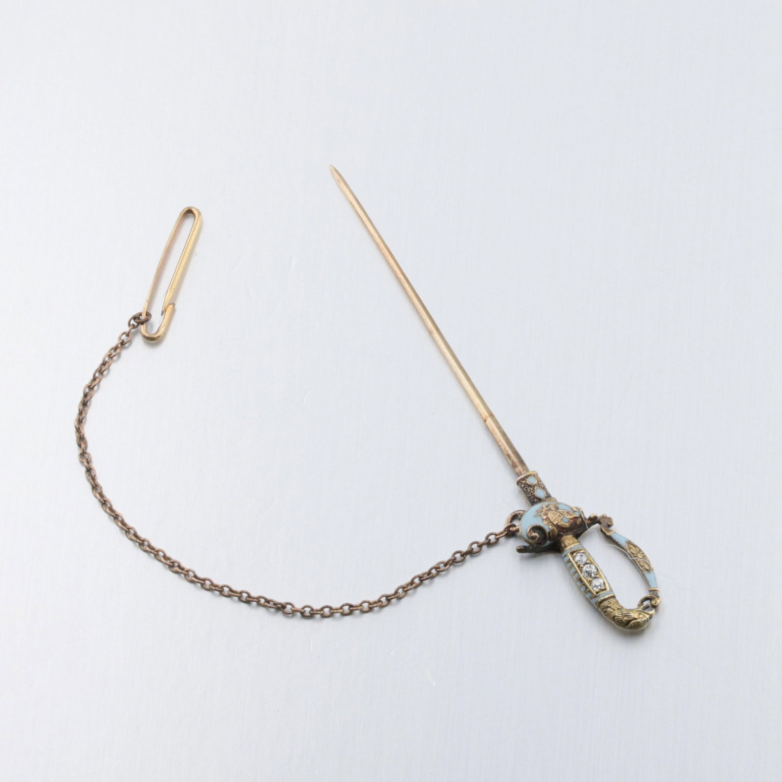 A 14K Gold Sword-Shape Stick Pin With Diamonds: Description: A Federal Saber Stick pin set with three European cut diamonds, and French blue enamel decorated with an American eagle with shield. Markings & Inscriptions: None Visible, testing as 18K 