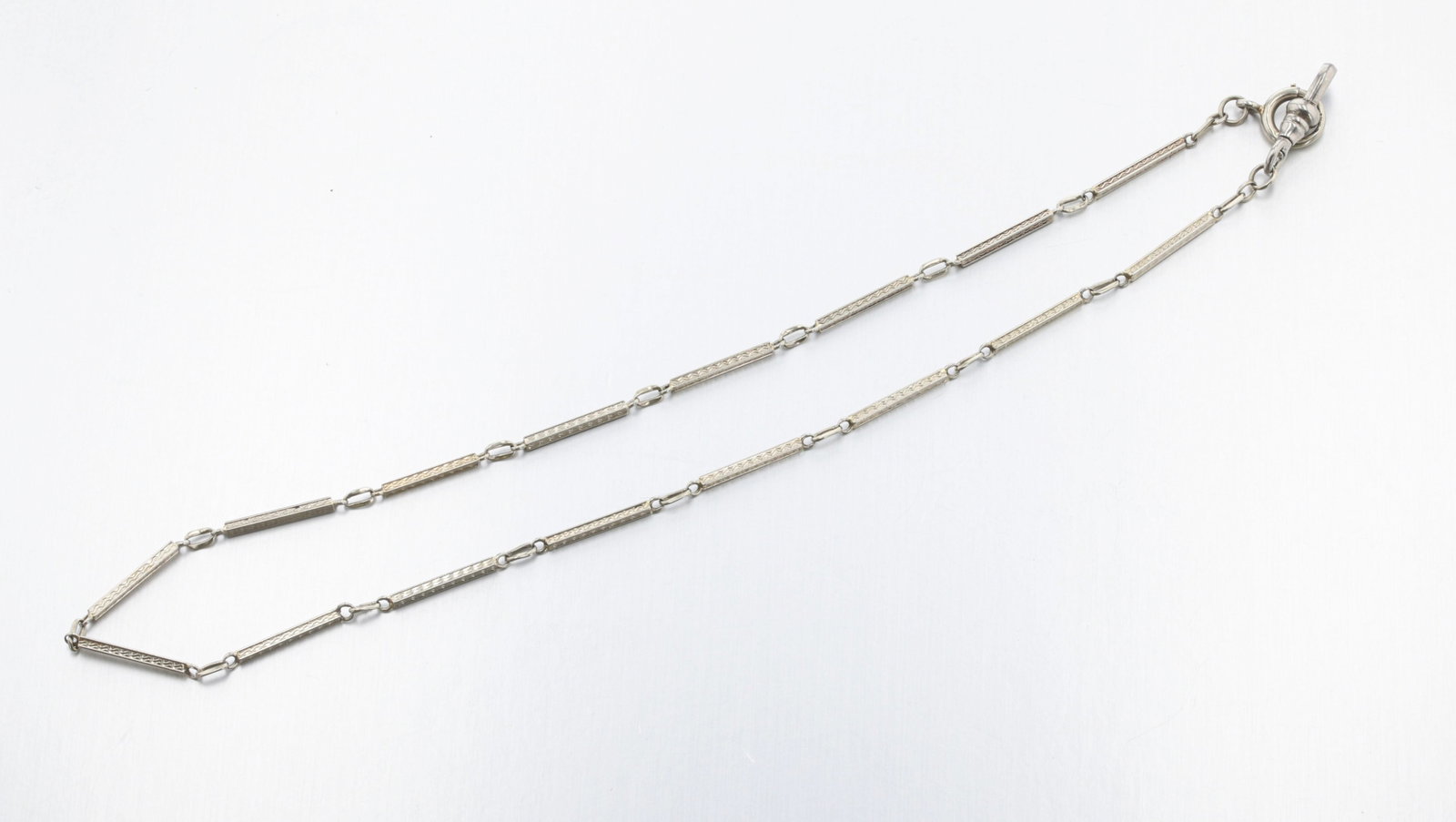 18K White Gold Art Deco Pocket Watch Chain: Description: An 18K White gold pocket watch chain with rectangular guilloche-engraved links. Markings & Inscriptions: None visible Date: 1920's, Art Deco Maker: Unknown Dimensions: Length: 15" Weight: