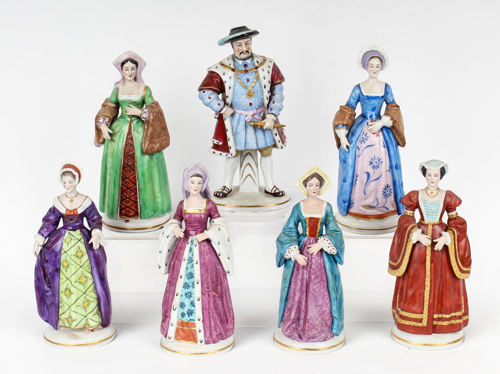 Sitzendorf Porcelain Henry VIII & Six Wives Porcelain Figurines: Description: A group of seven porcelain figurines by Sitzendorf, depicting King Henry VIII and six of his wives: Catherine of Aragon, Catherine Parr, Anne of Cleves, Jane Seymour, Anne Boleyn, and Cat