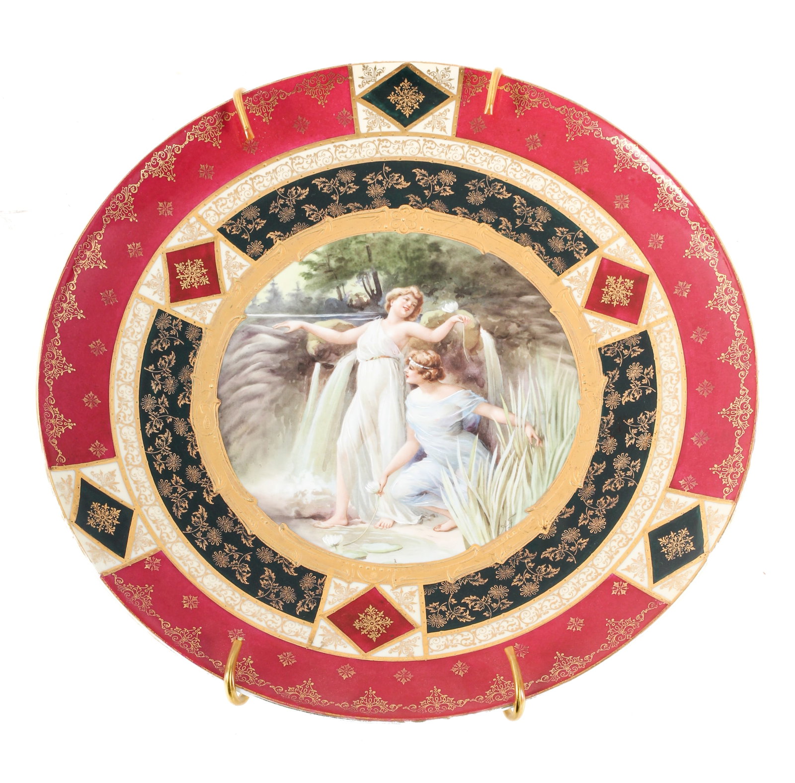 Royal Vienna Style Porcelain Wall Charger: Description: An antique hand painted porcelain wall charger with gilt elements featuring a hand-embellished depiction of two maidens near a pool of water. Markings & Inscriptions: Marked verso, initia