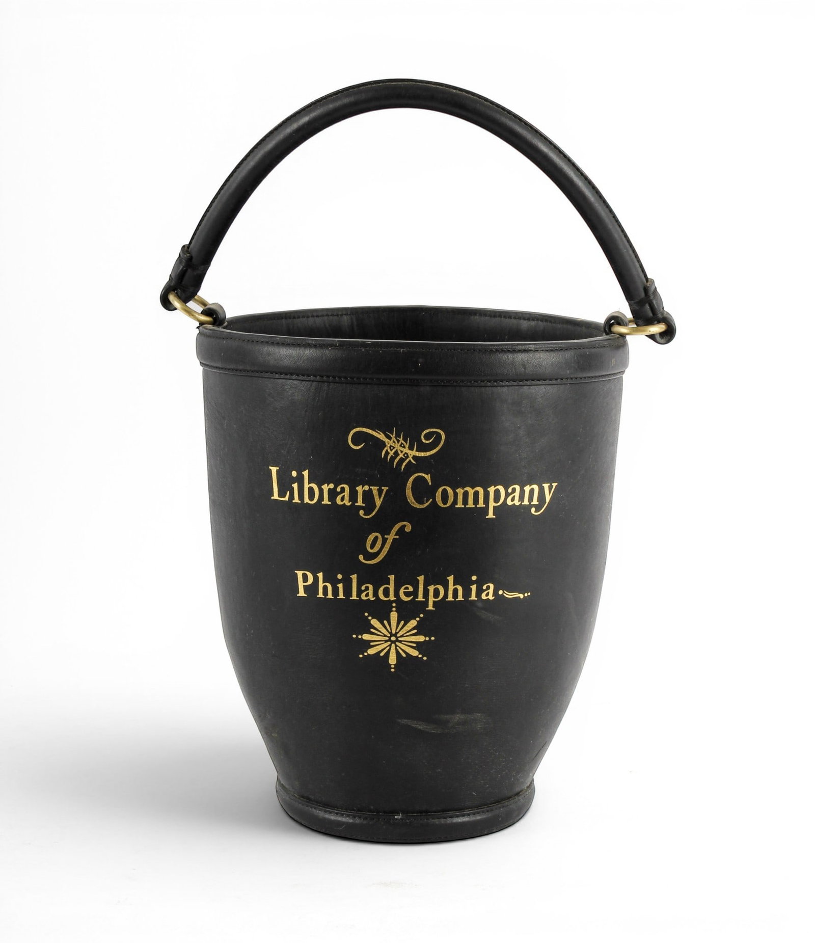 Library Company of Philadelphia Leather Fire Bucket, Levenger: Description: An 18th century replica fire bucket modeled after the original used by Benjamin Franklin's Library Company of Philadelphia; produced by Levenger. Markings & Inscriptions: Marked Date: Ear